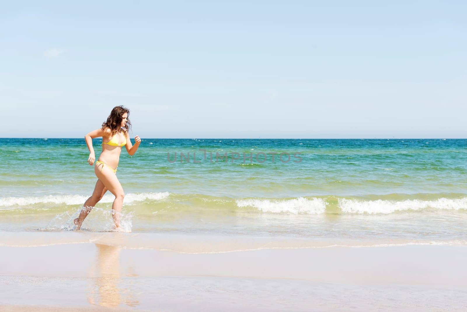 happy woman in bikini running on the beach