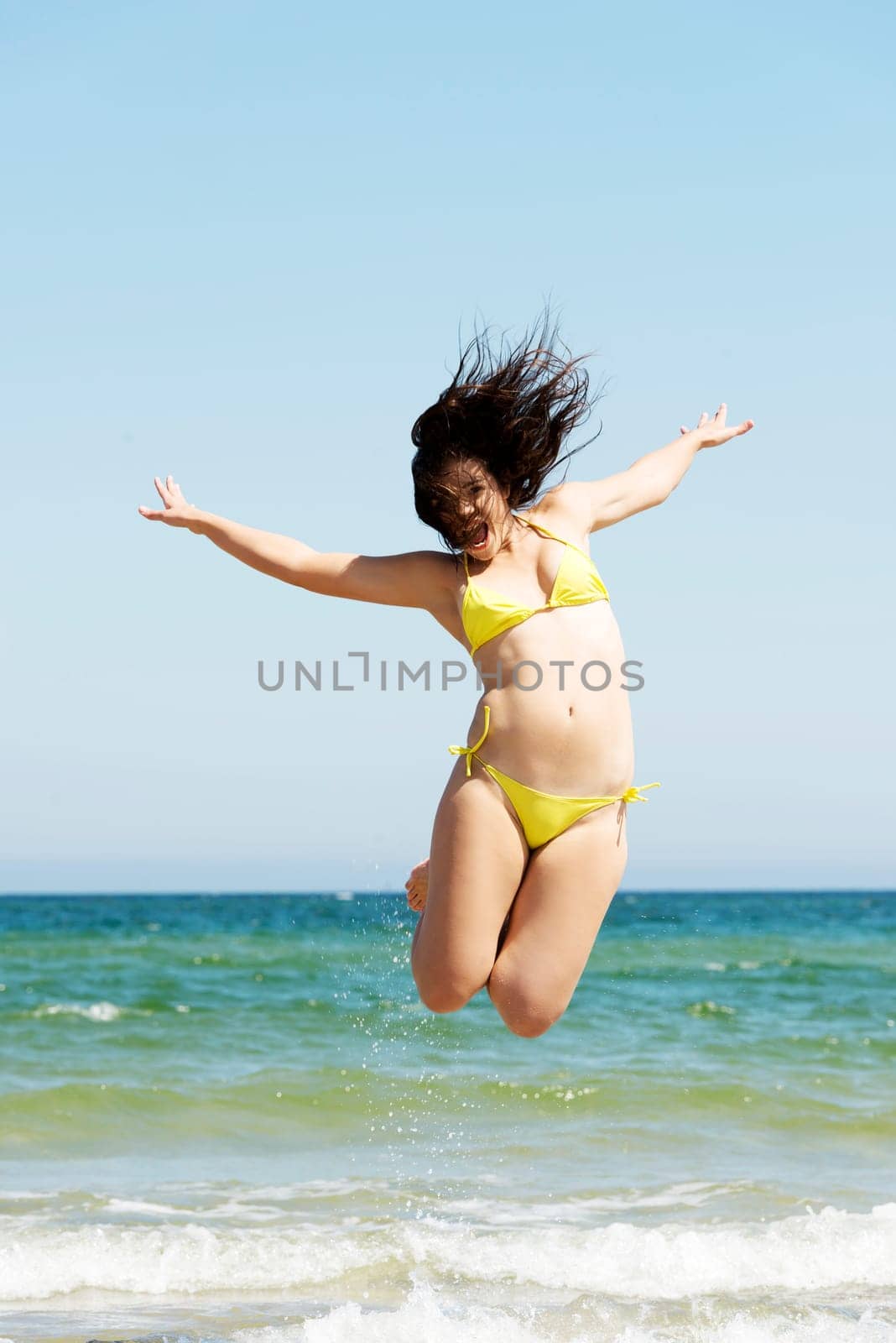 happy free girl jumping on the beach