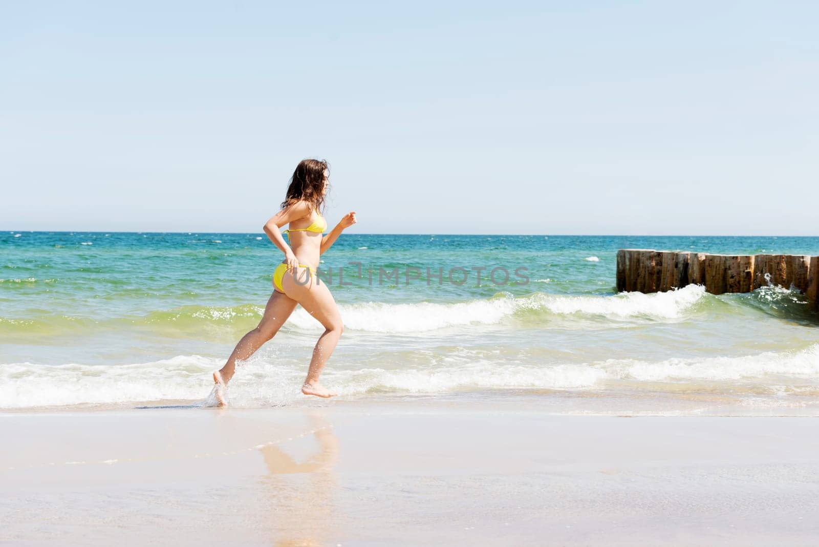 happy woman in bikini running on the beach