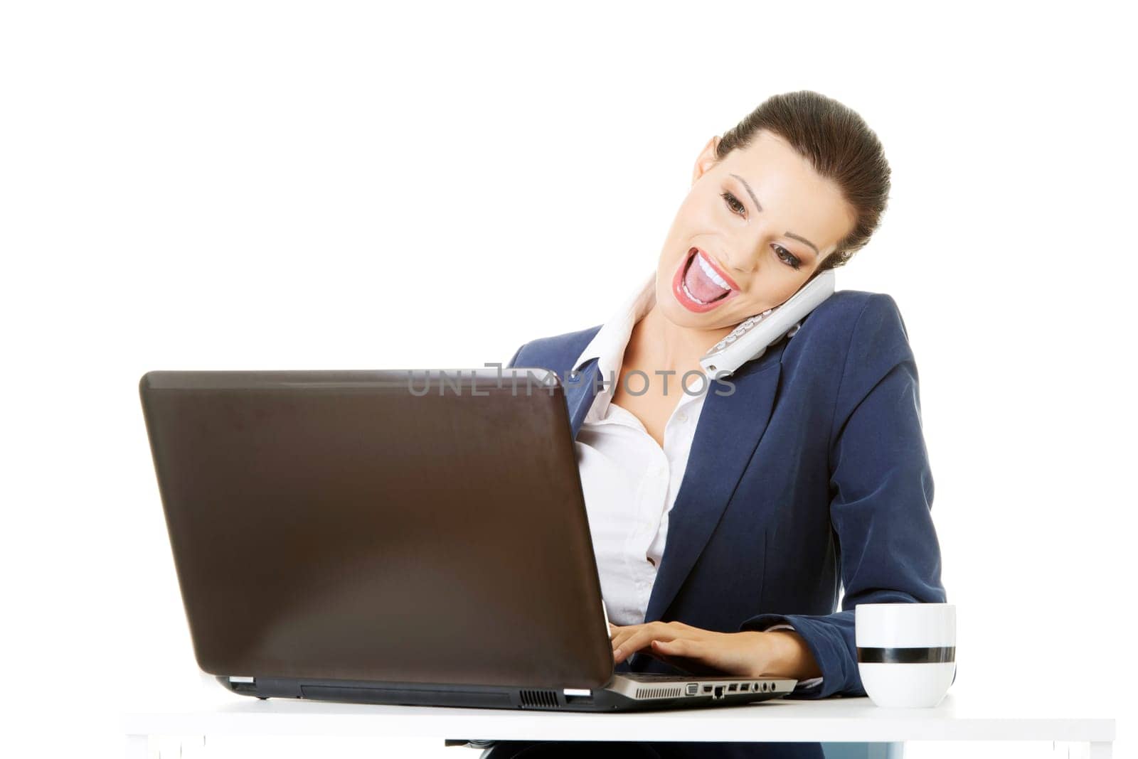smiling young business woman speaking on phone while using a laptop,isolated on white