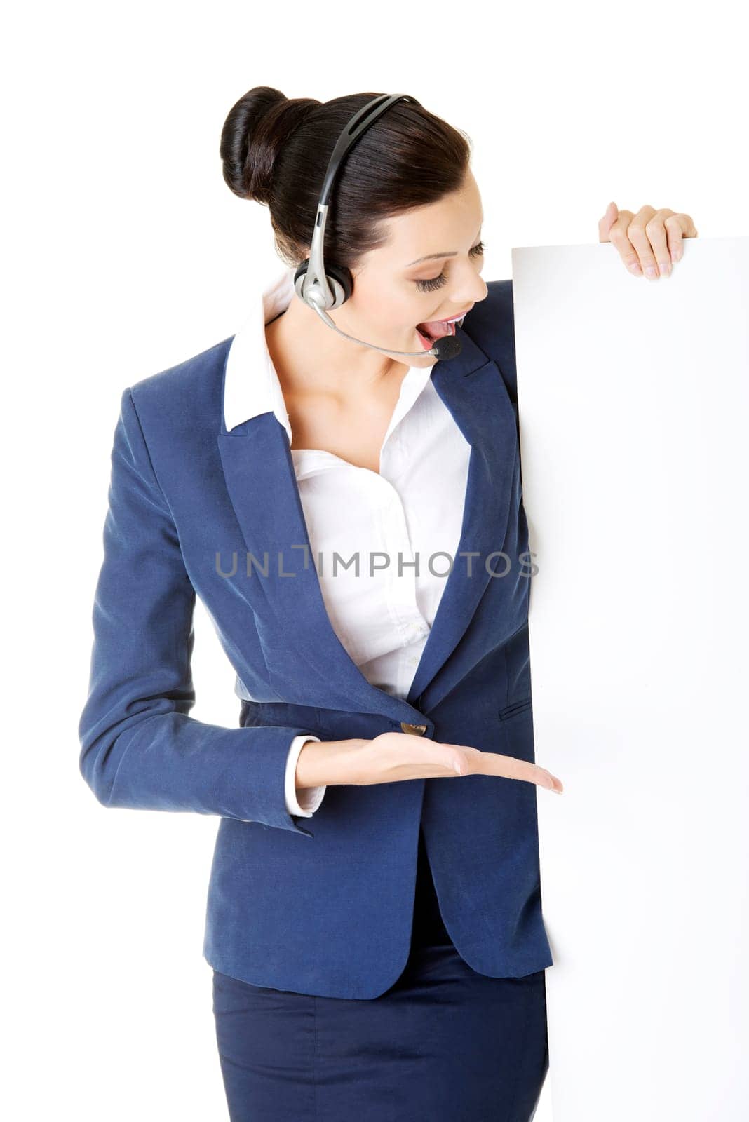 pretty young call center worker wearing a headset and holding blank sign board