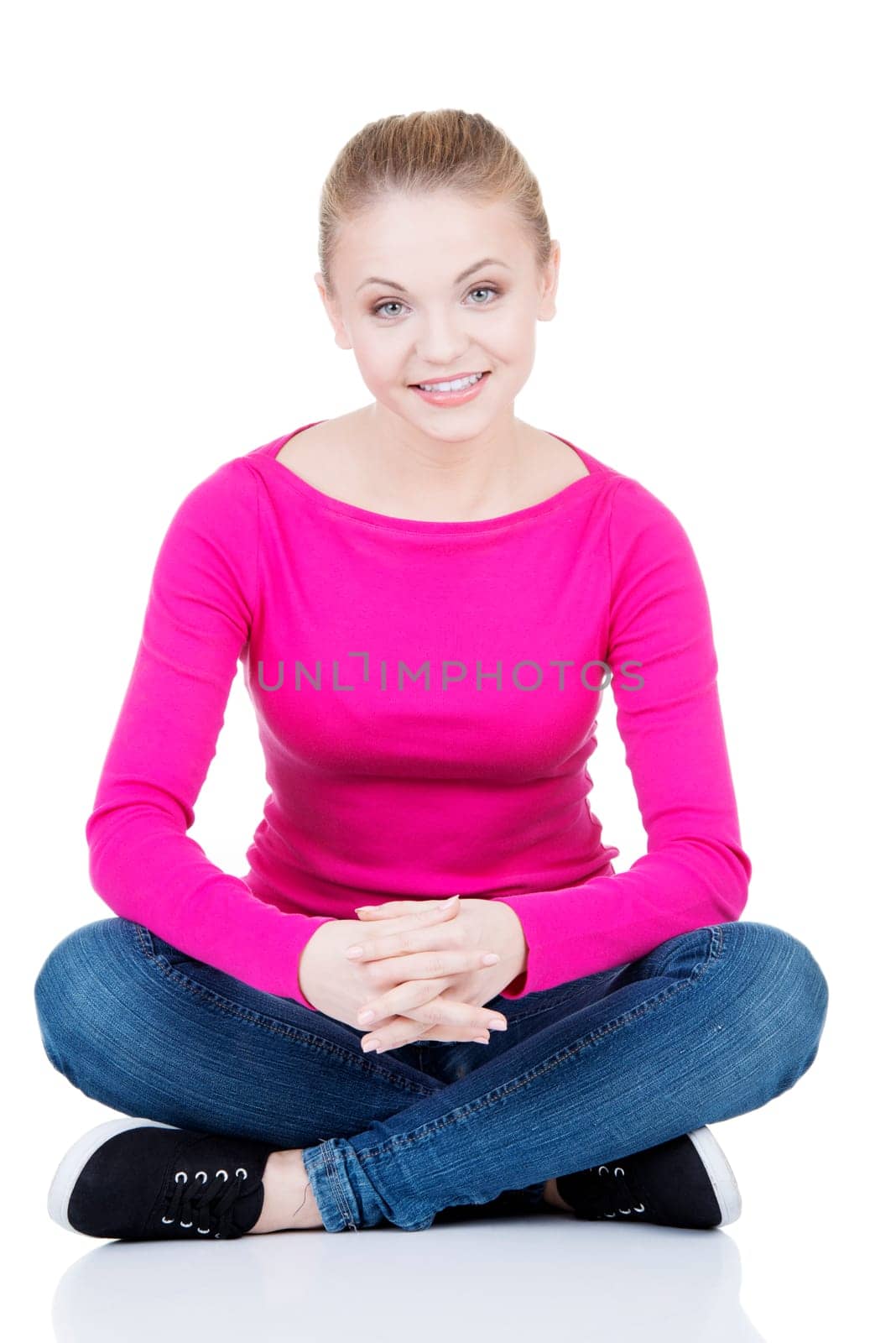 yong happy casual woman sitting on floor,isolated on white background