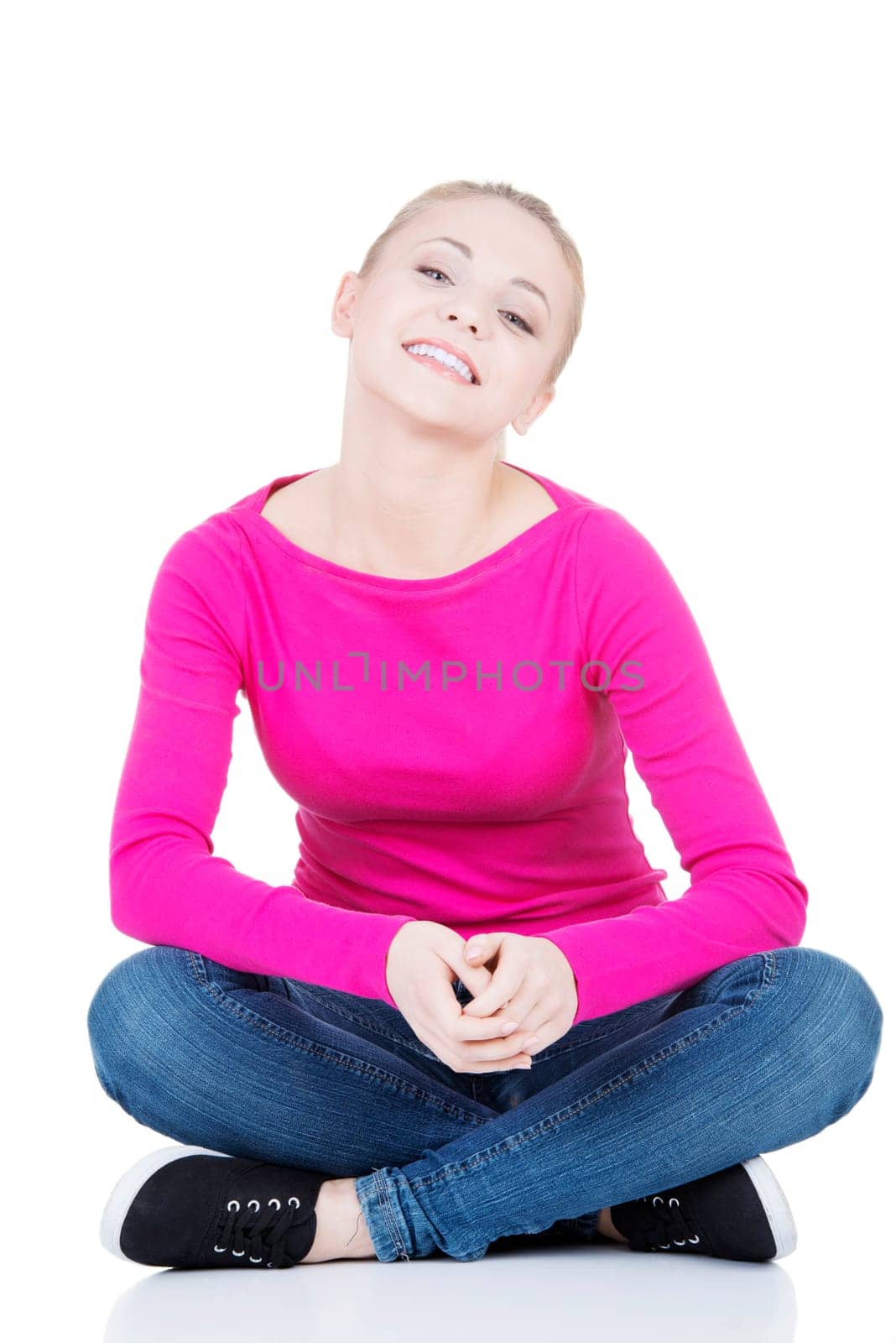 yong happy casual woman sitting on floor,isolated on white background
