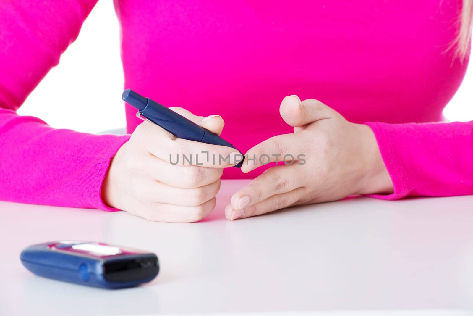 diabetes patient measuring glucose level blood test using ultra mini glucometer and small drop of blood from finger isolated on a white background