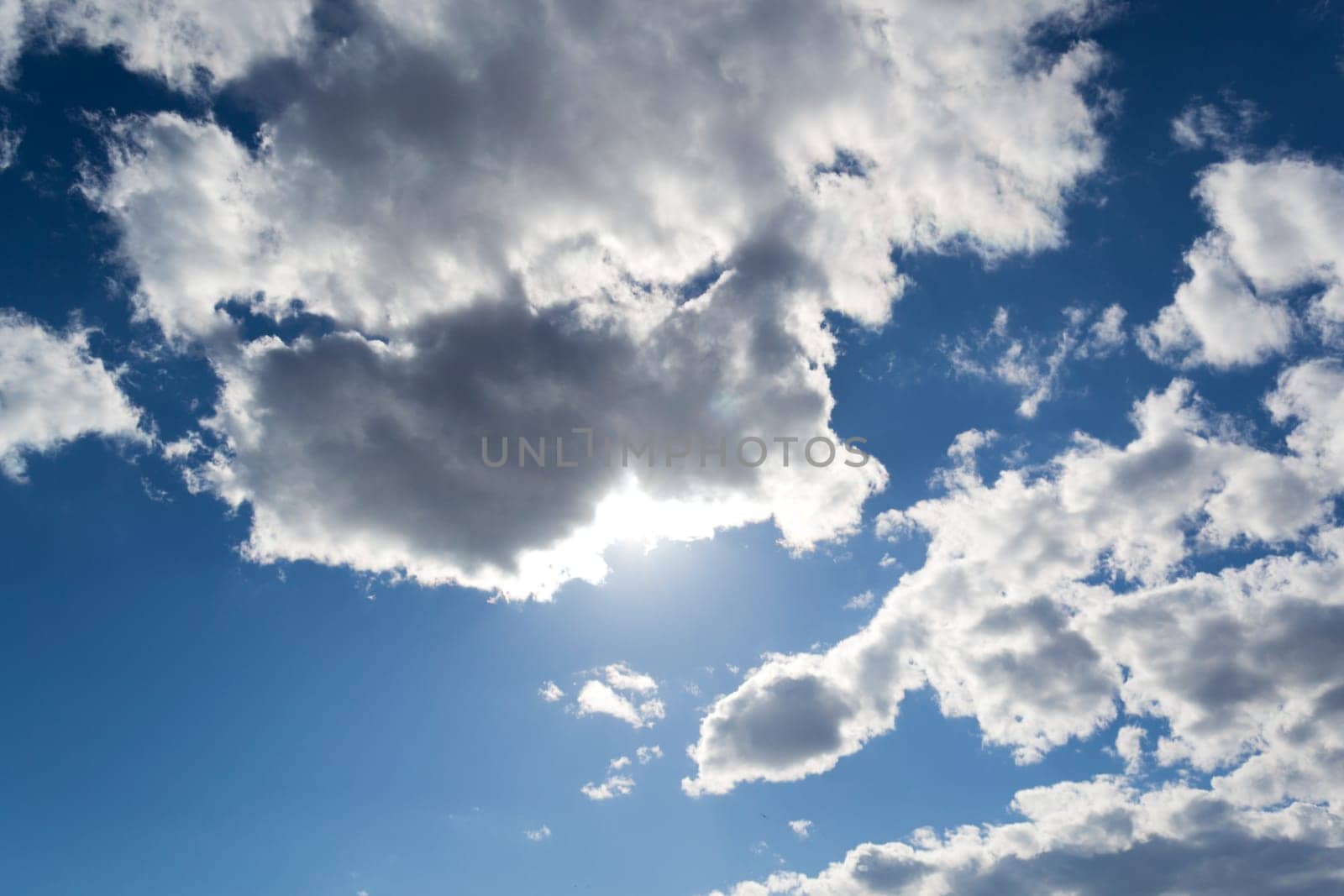 A blue sky with gray clouds and sunshine
