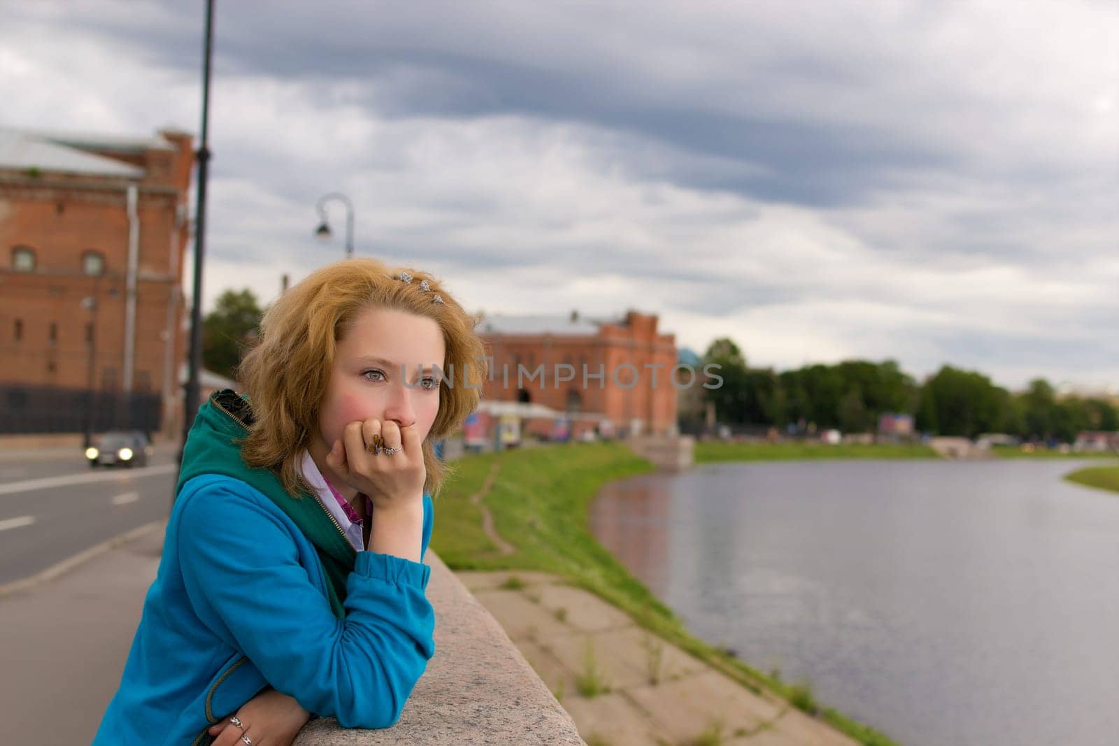 Beautiful thoughtful girl stands near the river