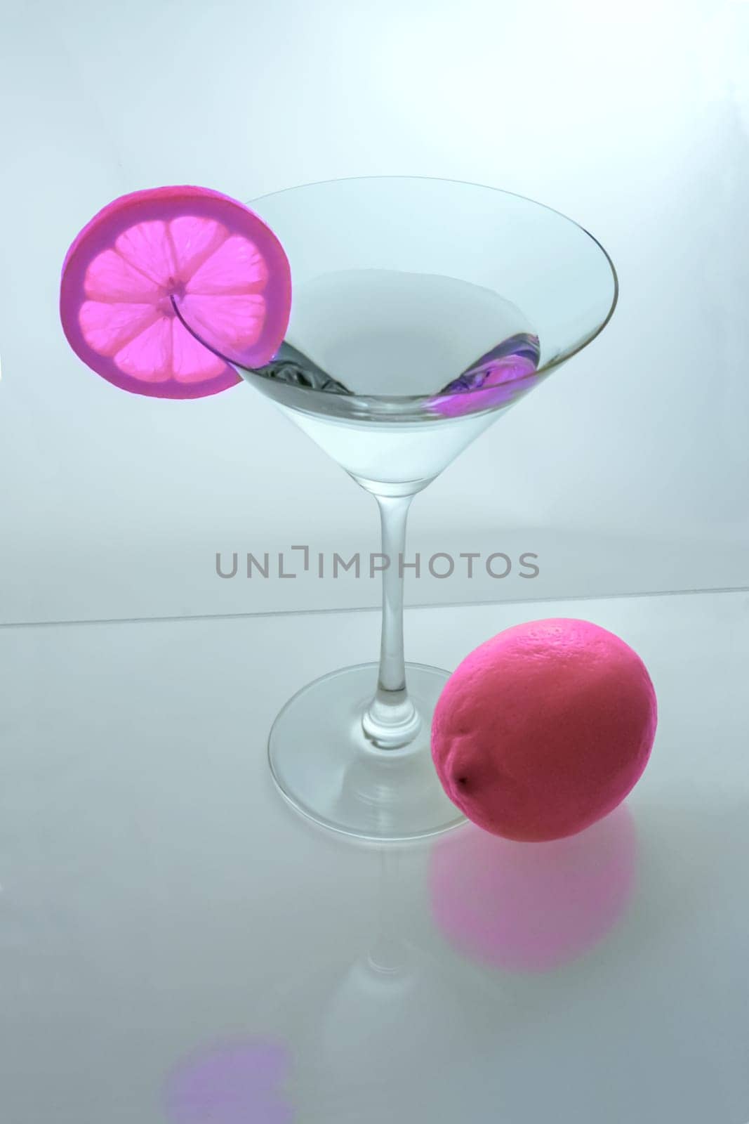 Martini glass with pink lemon slice and pink lemon from above