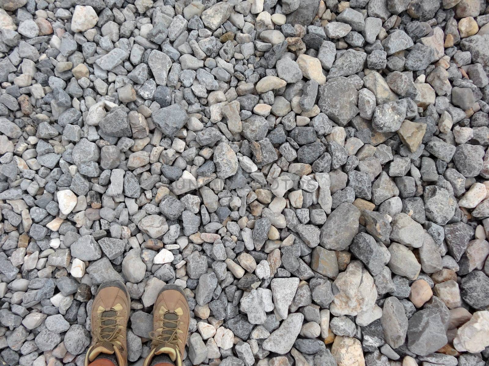 Horizontal shot of a pair of hiking boots on gravel from above