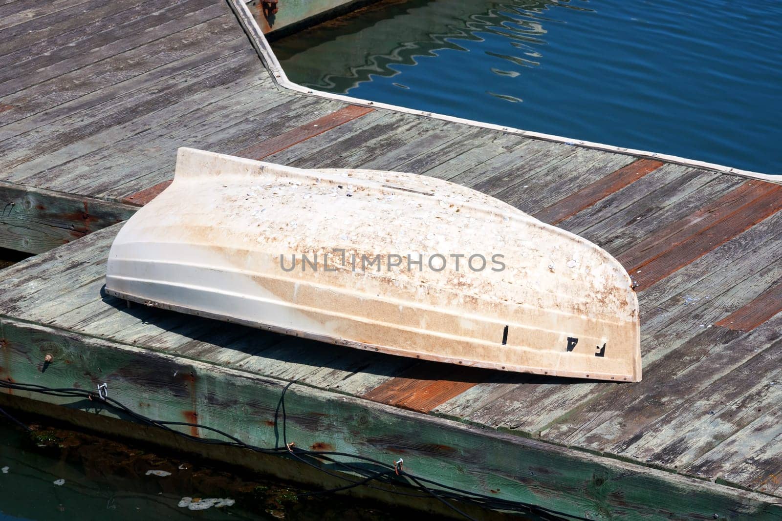 An old boat abandoned and turned over on a pier