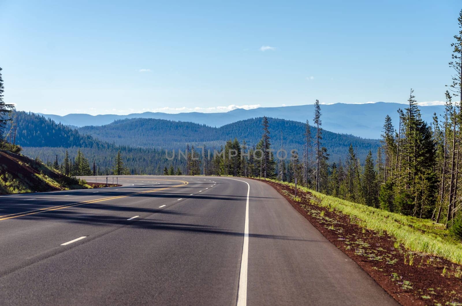 Highway curving through a dramatic nature scene in Central Oregon
