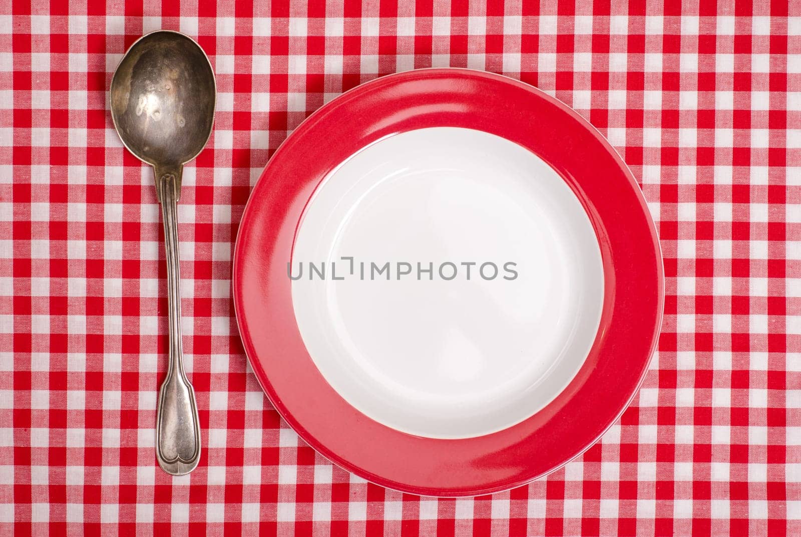 Red checkered tablecloth with silver spoon and plate