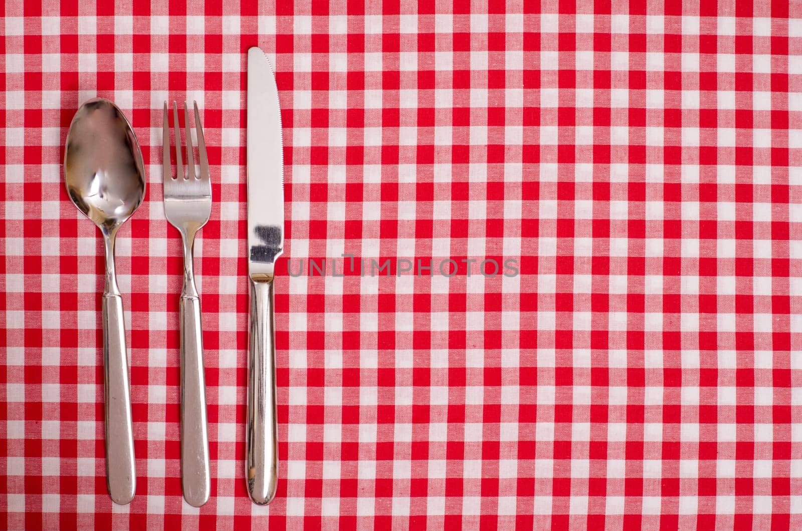 Spoon,knife and fork on a table with checkered cloth