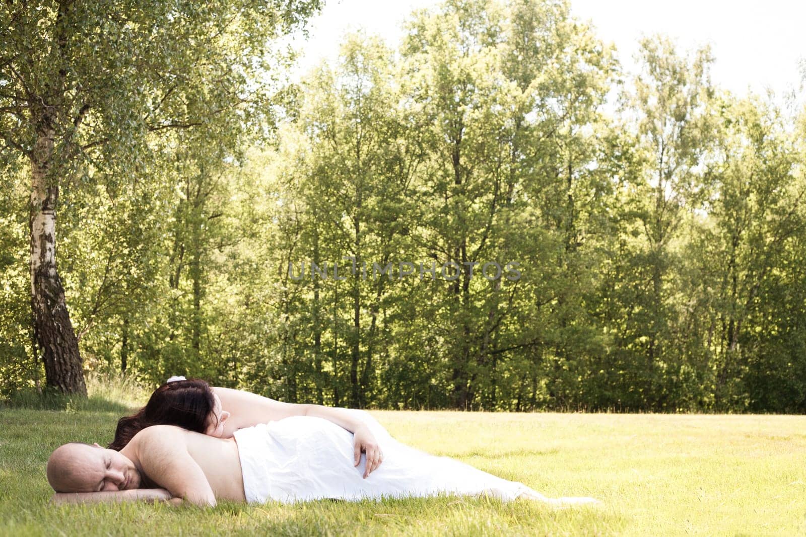 Happy young couple dressed white in the nature