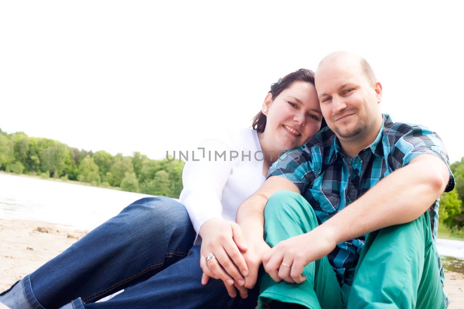 Happy young couple is having fun on a windy park beach