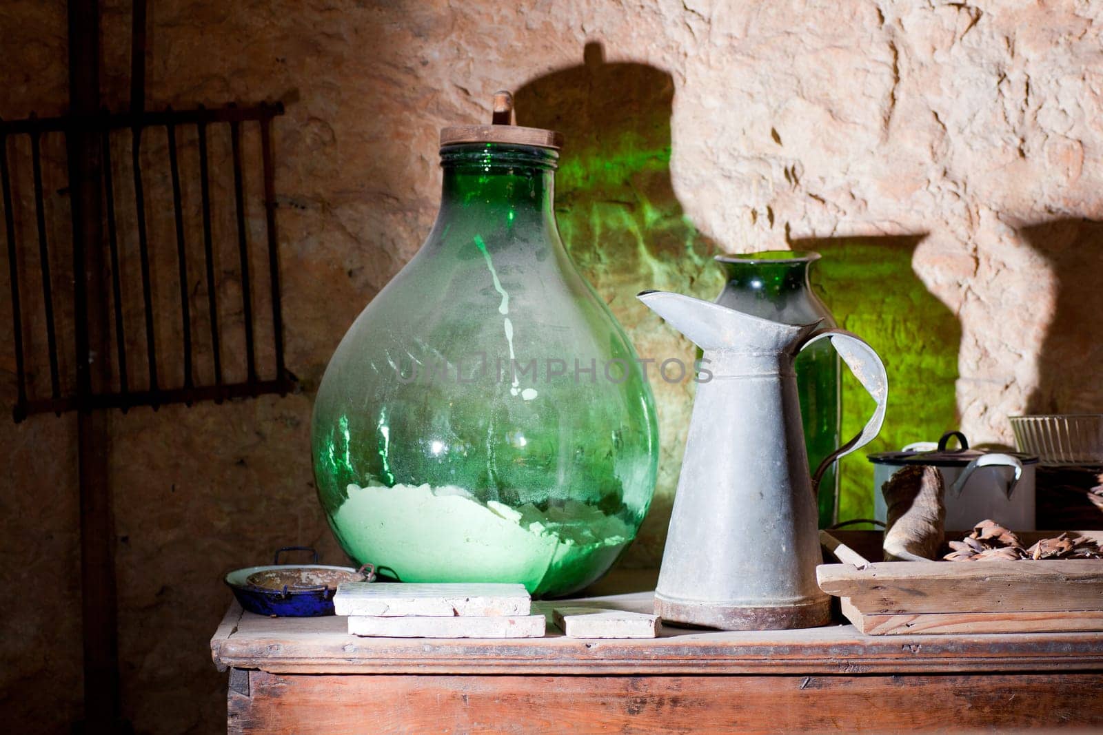 Photo of an iron pitcher and glass demijohn