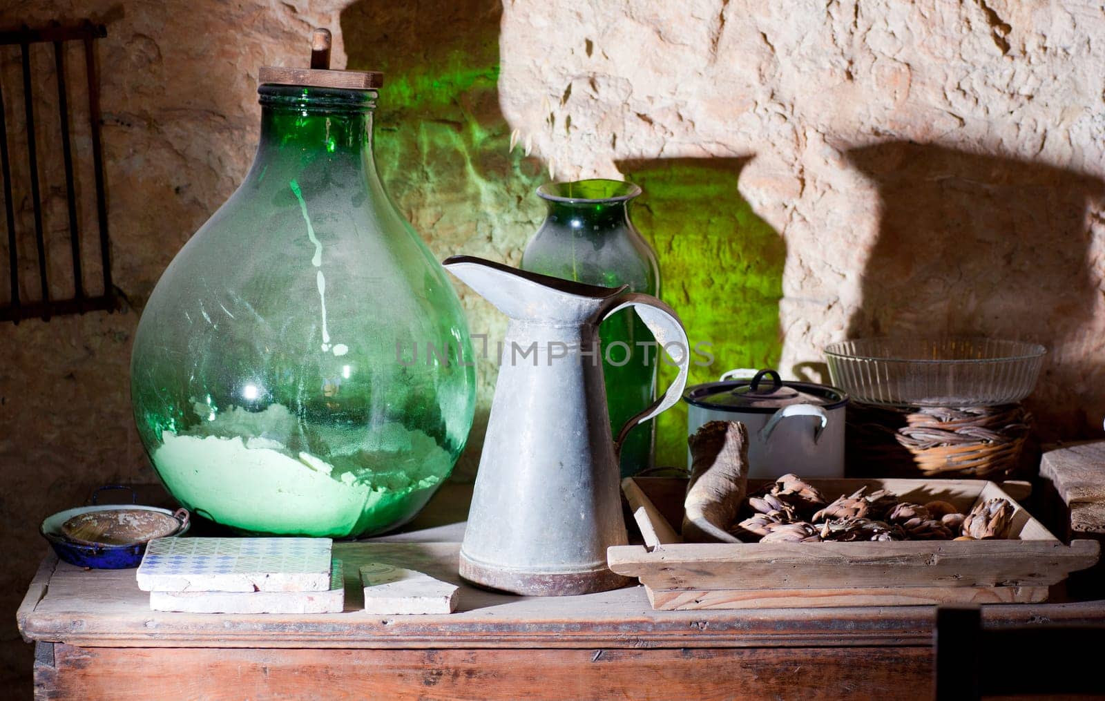 Photo of an iron pitcher and glass demijohn