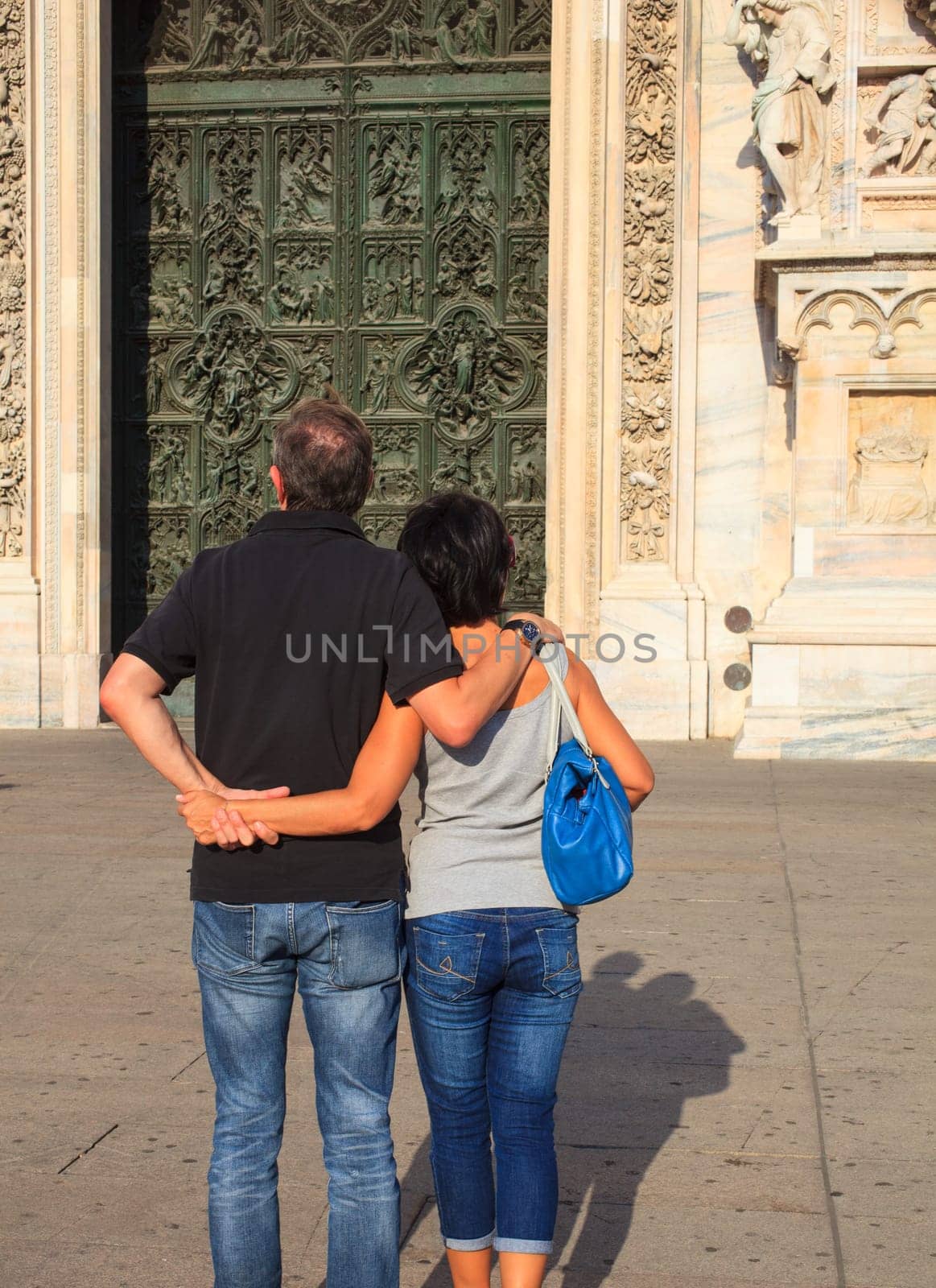 Couples looking the portal of the Milan cathedral
