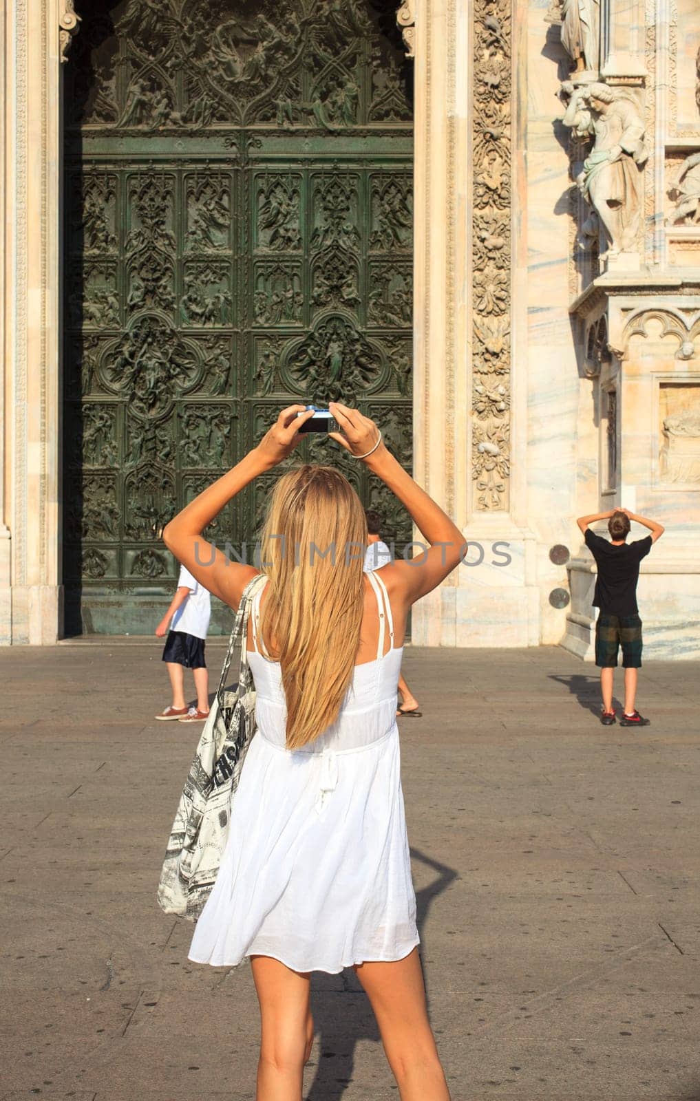 Woman photographing the portal of the Milan cathedral