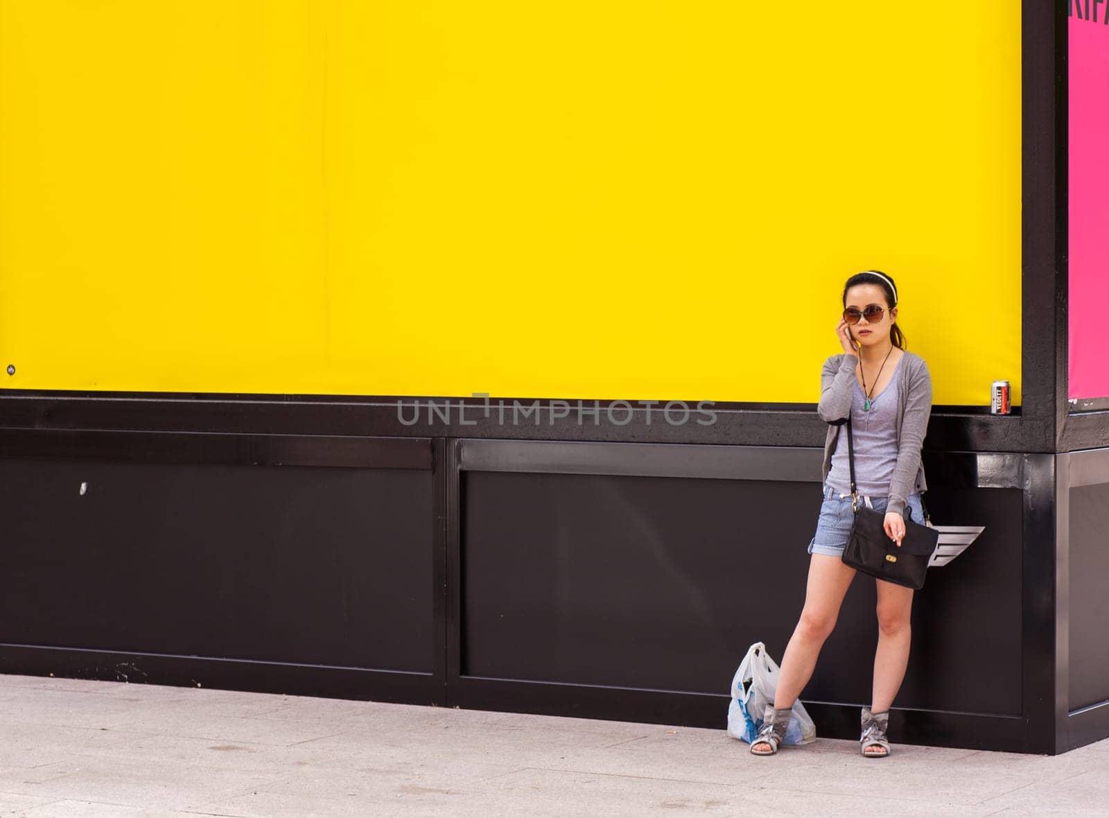 Teenager oriental girl on yellow wall. Fuori salone, Triennale - Mini car exhibition- .http
