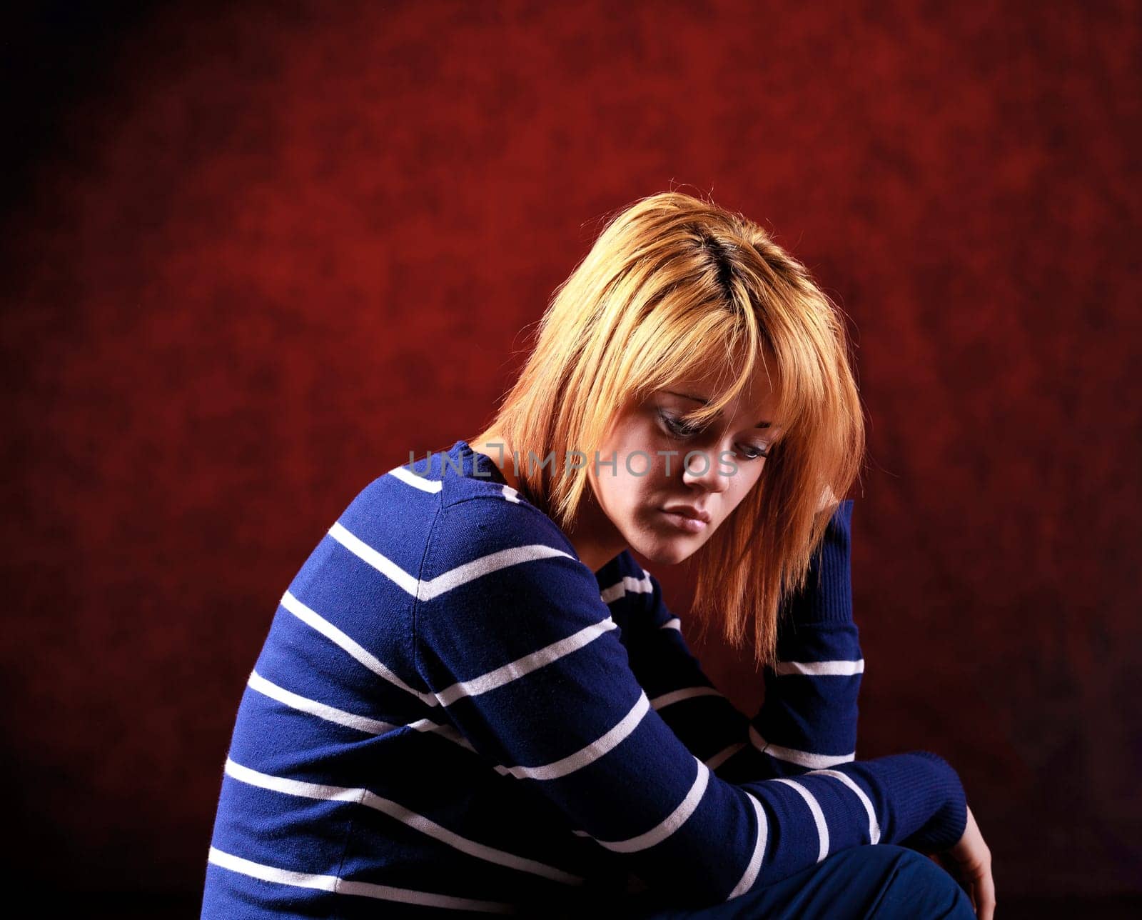 Girl sitting on the stool on red background