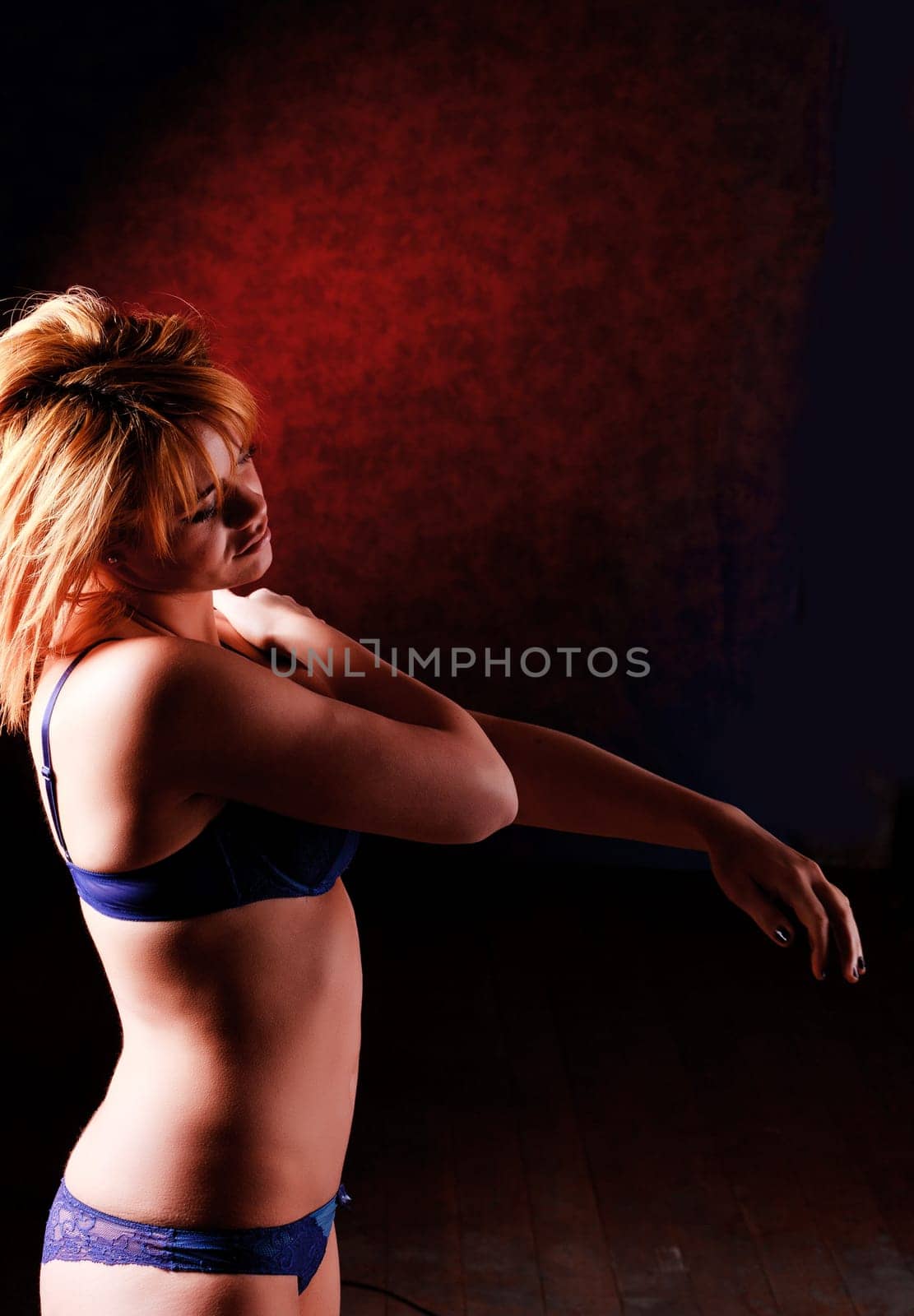 Sensual blonde girl in underwear on dark background