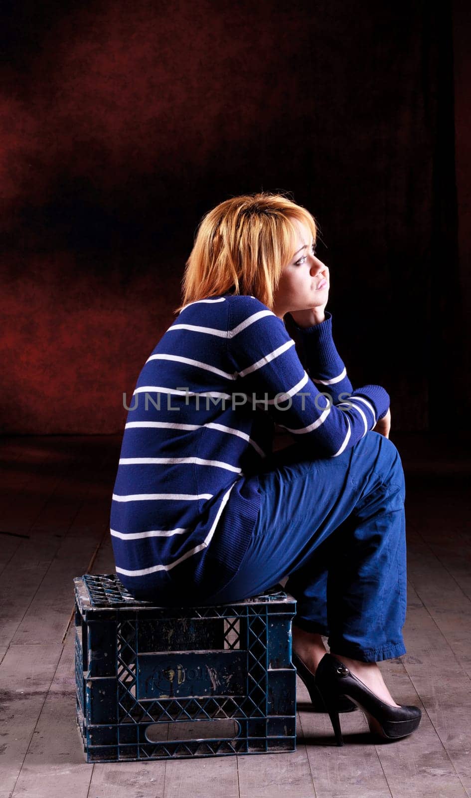Girl sitting on the stool on dark background