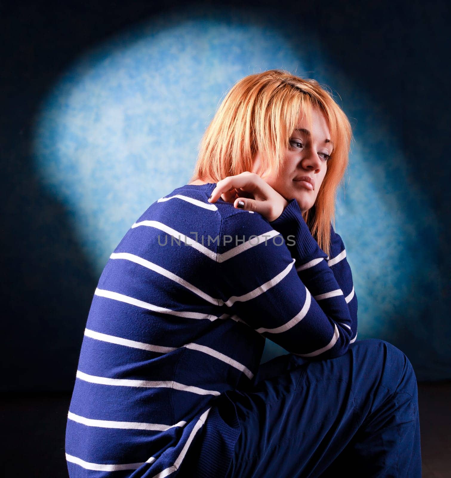 Girl sitting on the stool on dark background