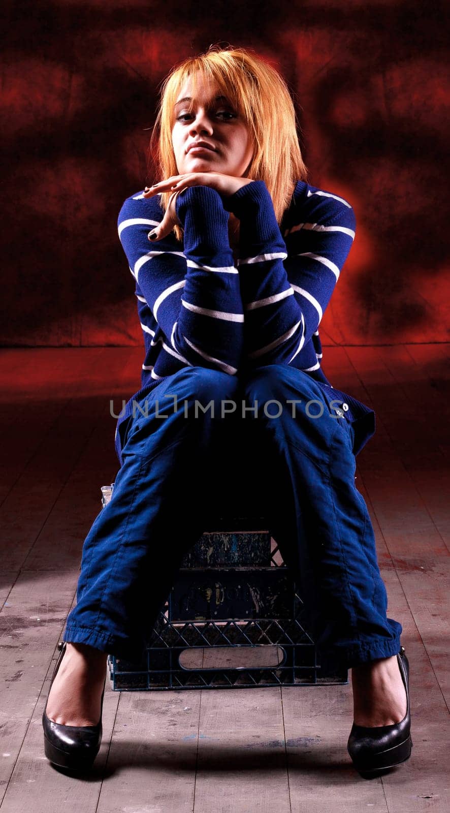 Girl sitting on the stool on red background