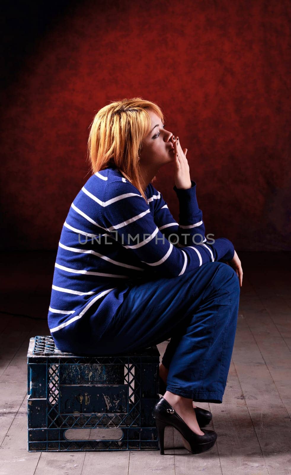 Girl sitting on the stool on red background