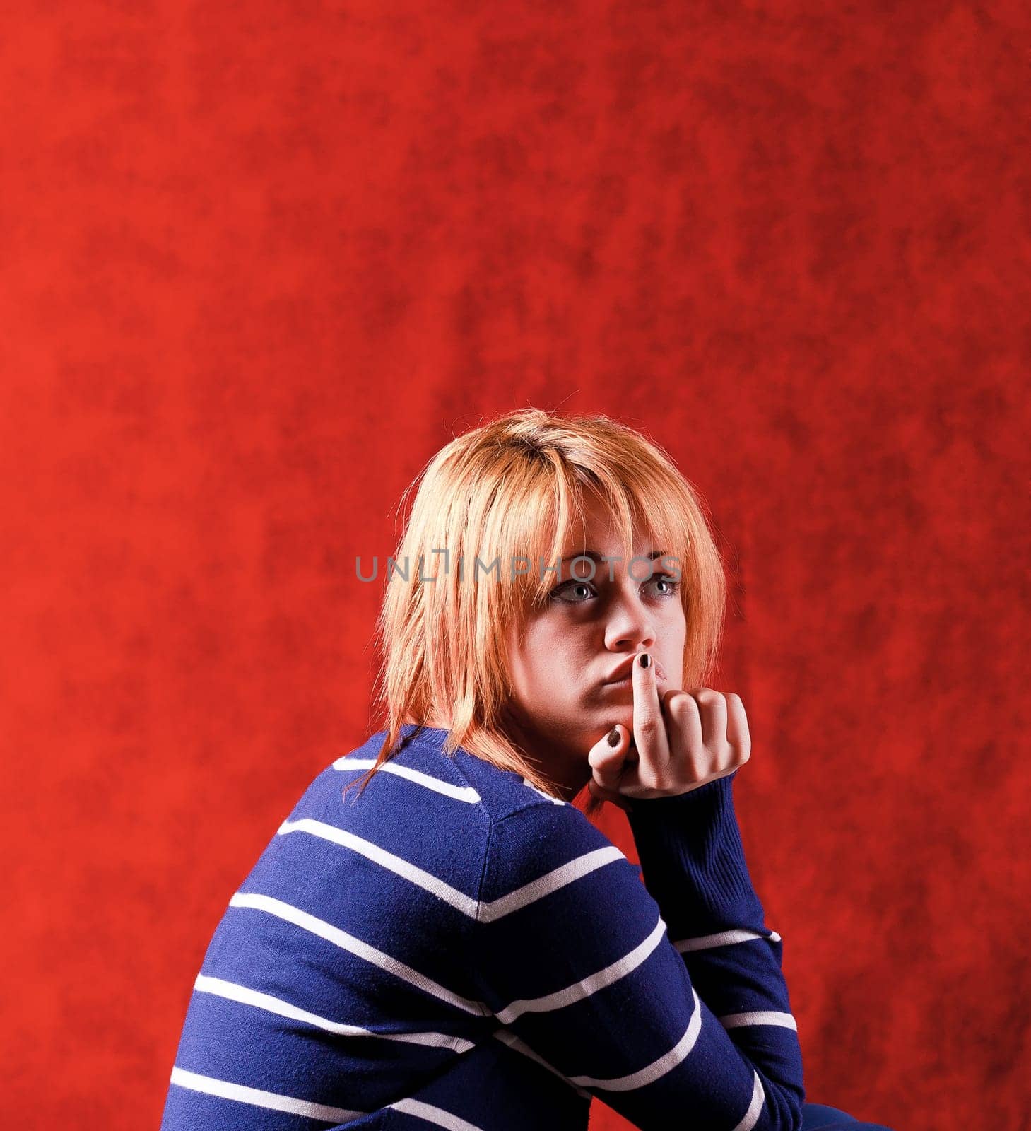 Girl sitting on the stool on red background