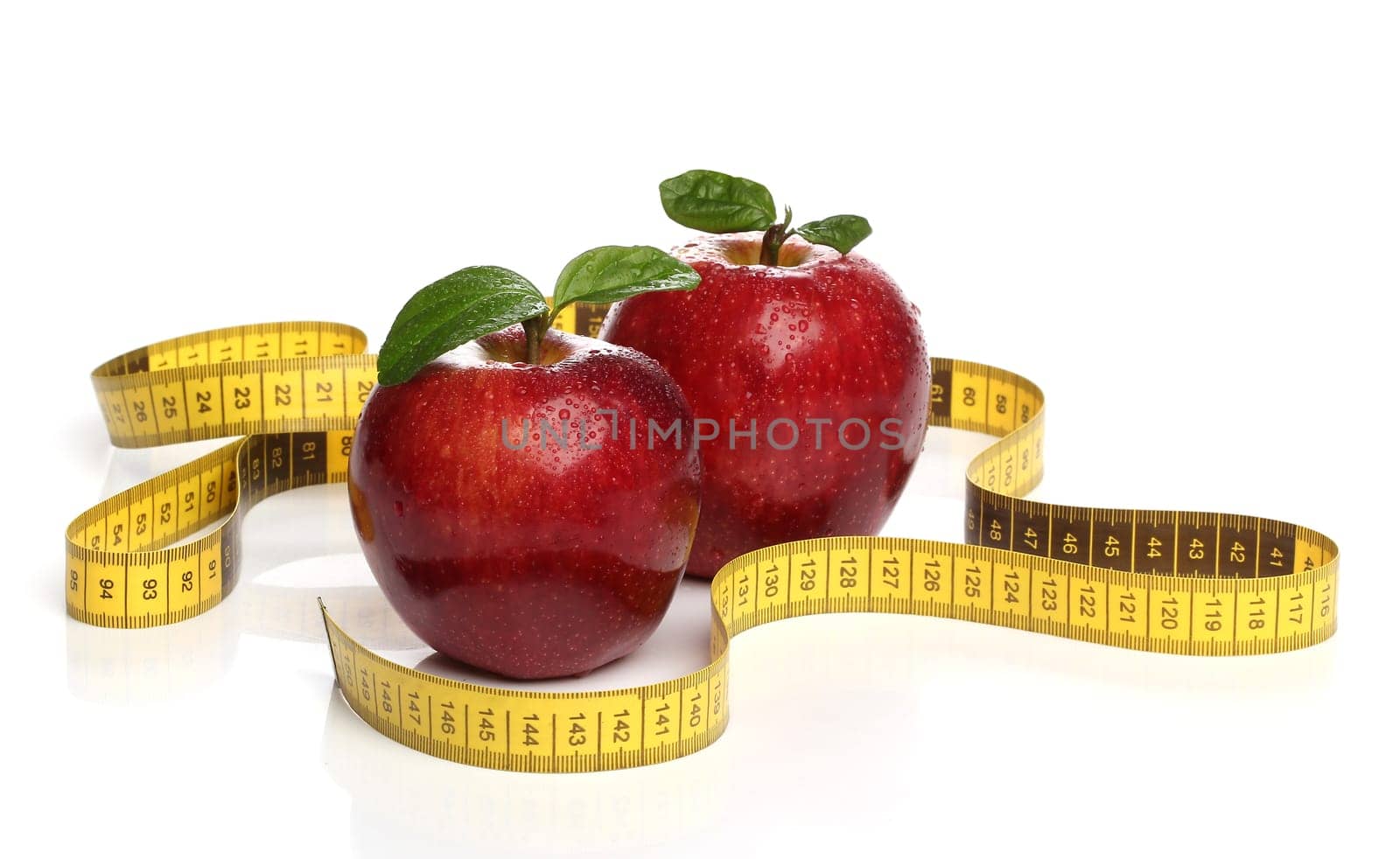 Red apples and a measuring tape over white