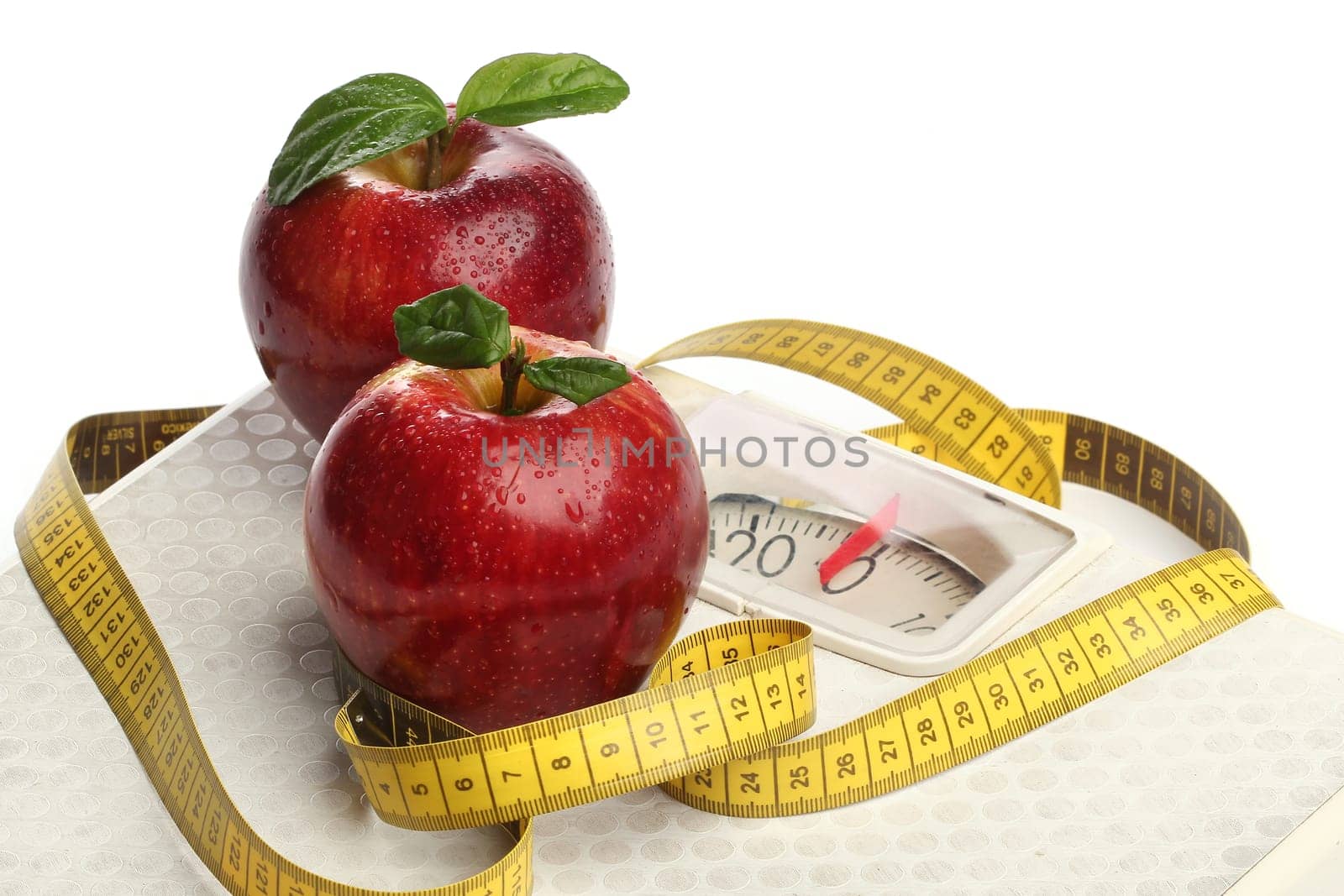 Red apples and a measuring tape over white