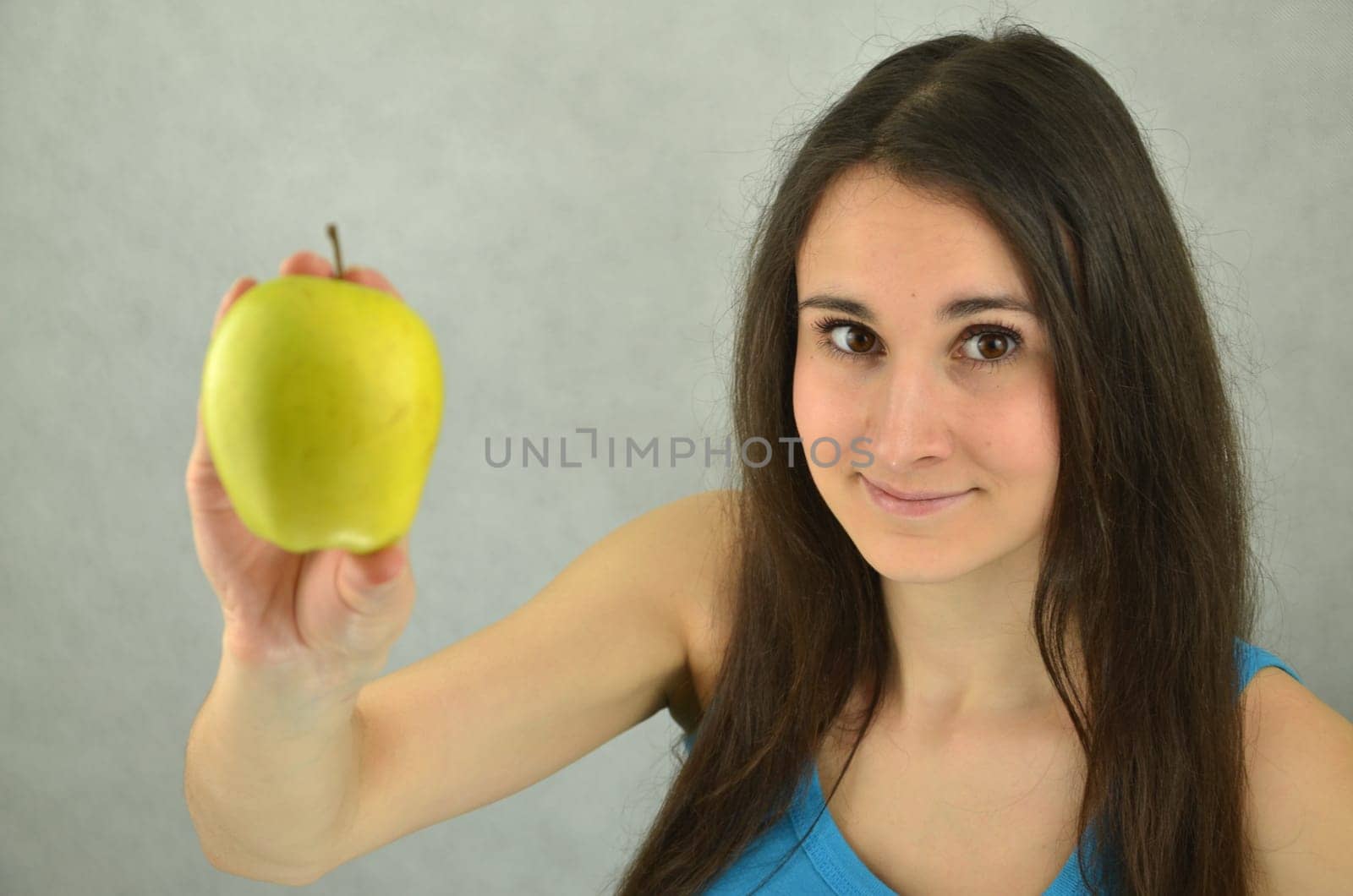 Beautiful young girl is holding an apple
