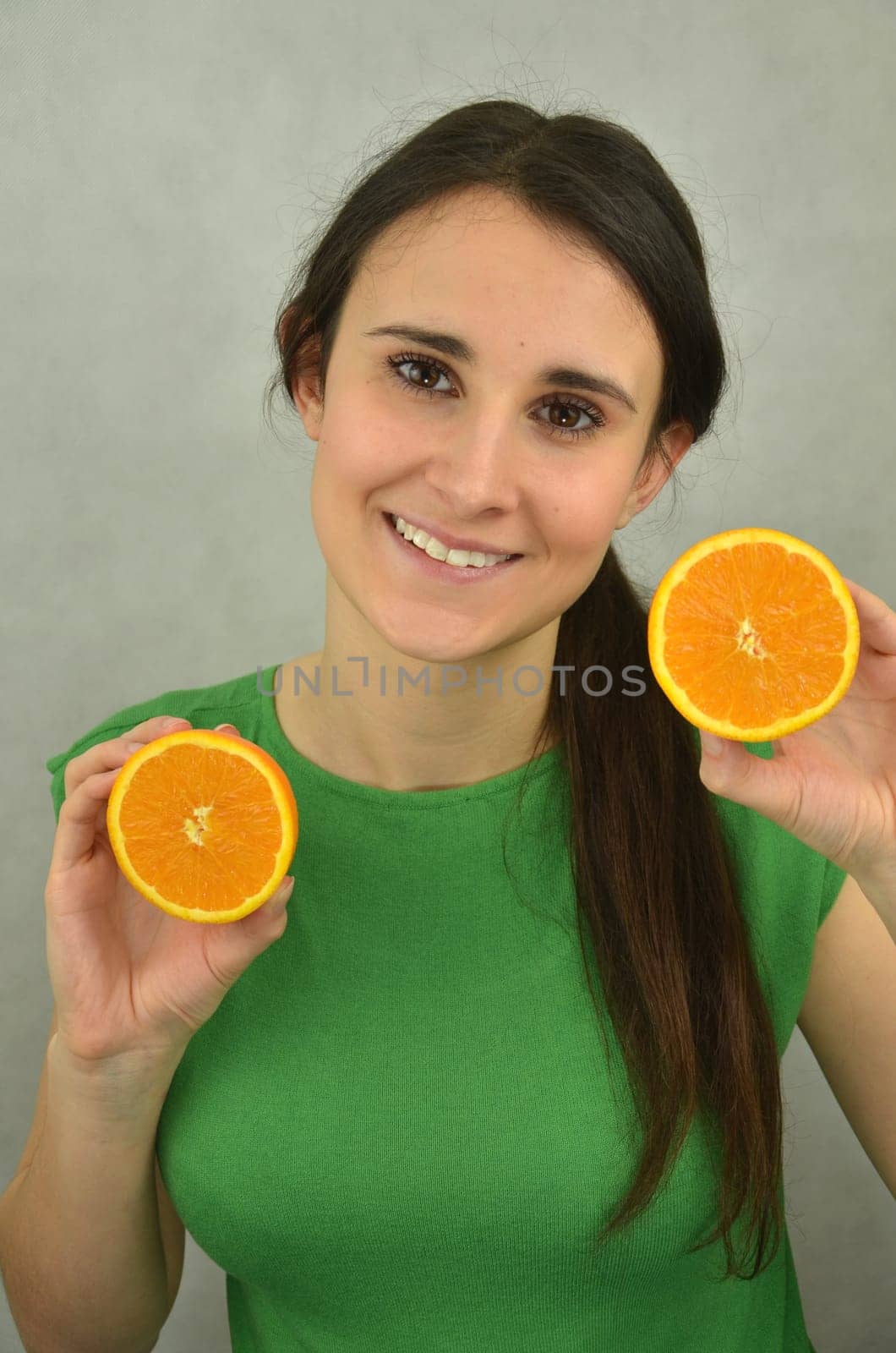 Beautiful young girl is holding an orange