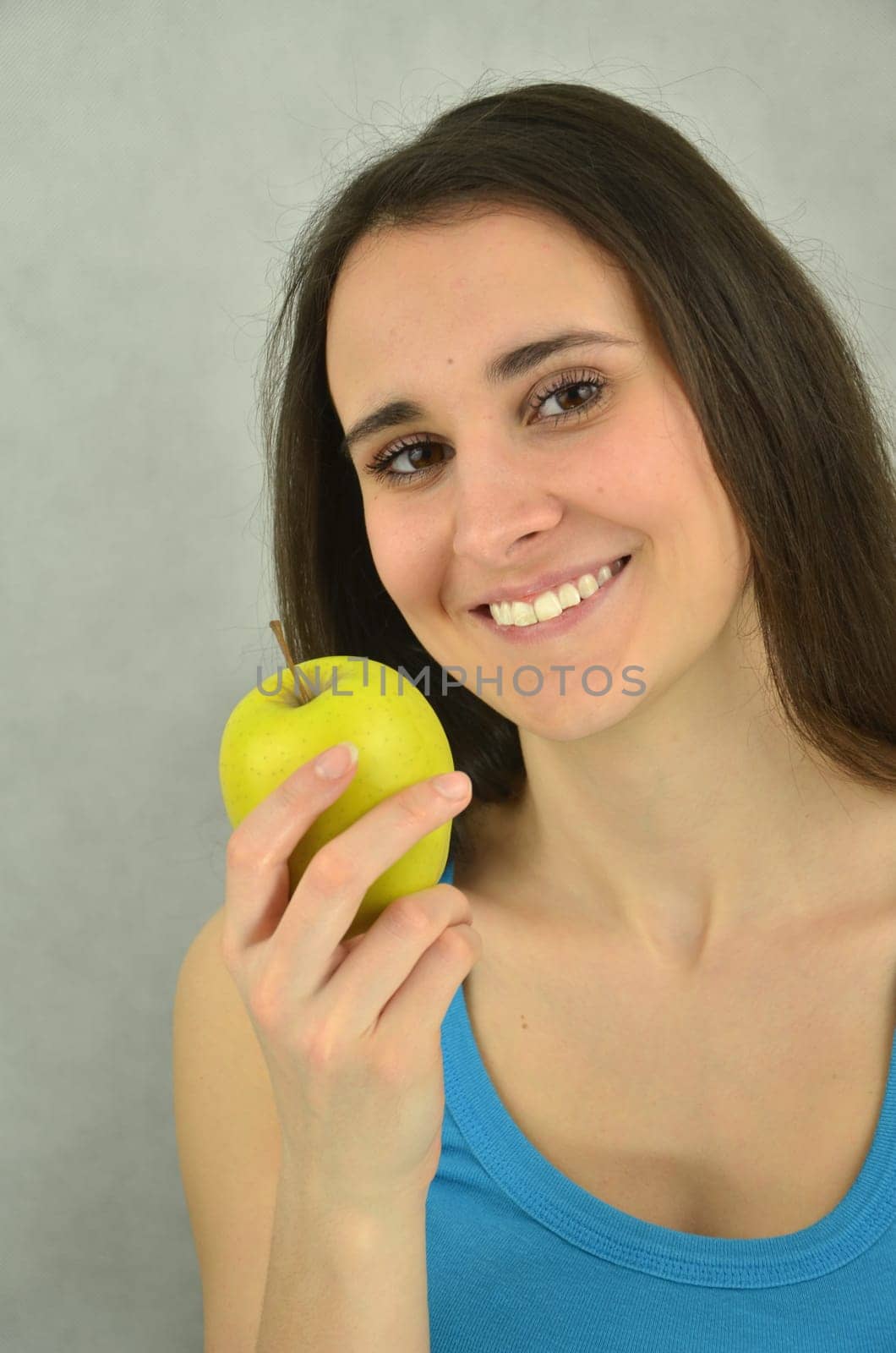 Beautiful young girl is holding an apple