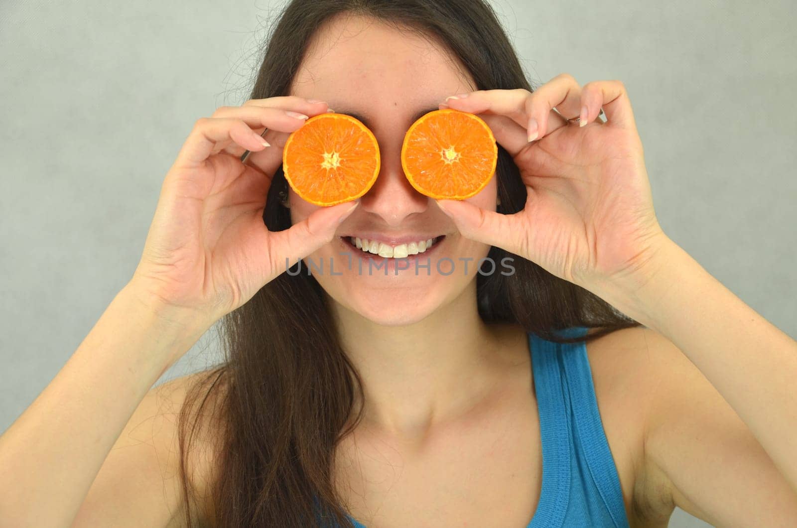 Beautiful young girl is holding tangerine
