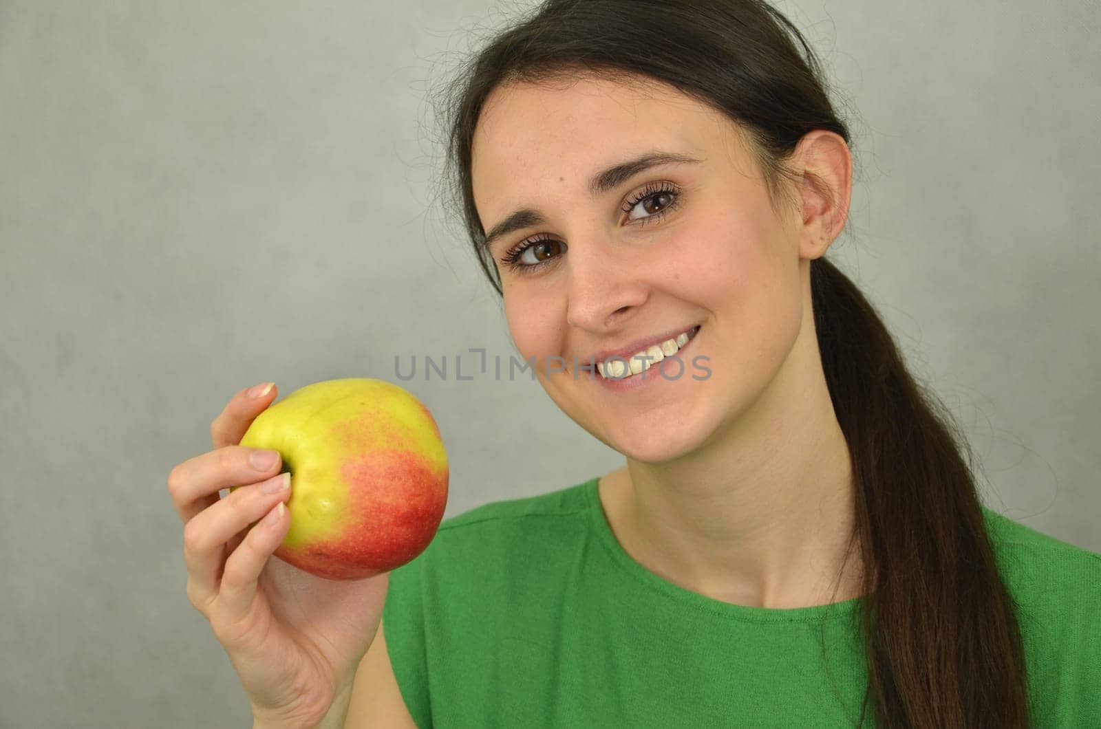 Beautiful young girl is holding an apple