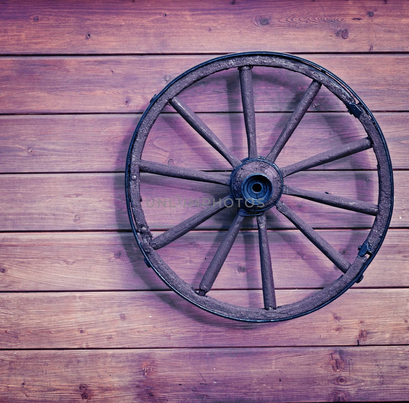 Vintage wooden wheel on the old wall