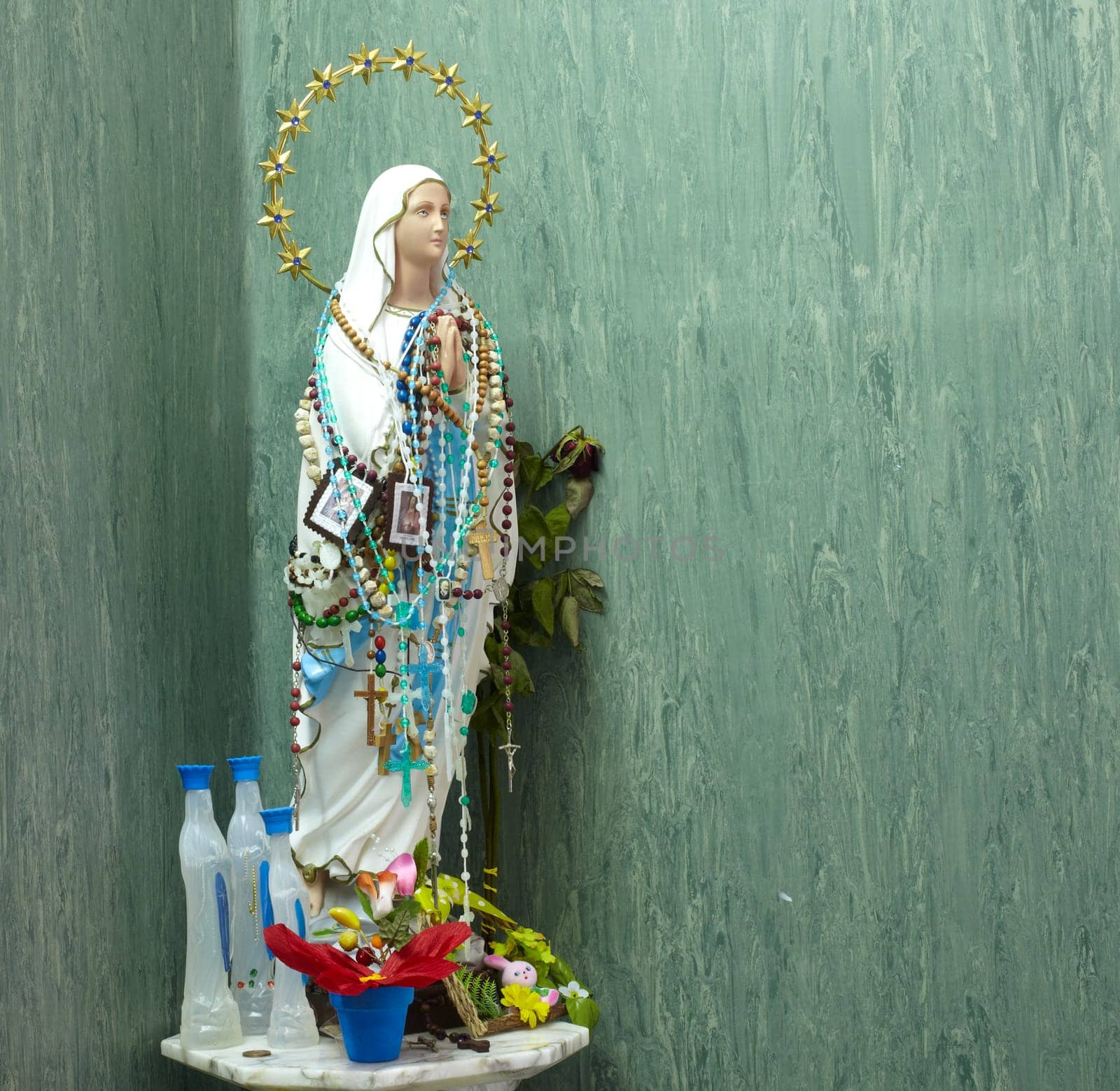 Statue of Virgin Mary covered with rosaries