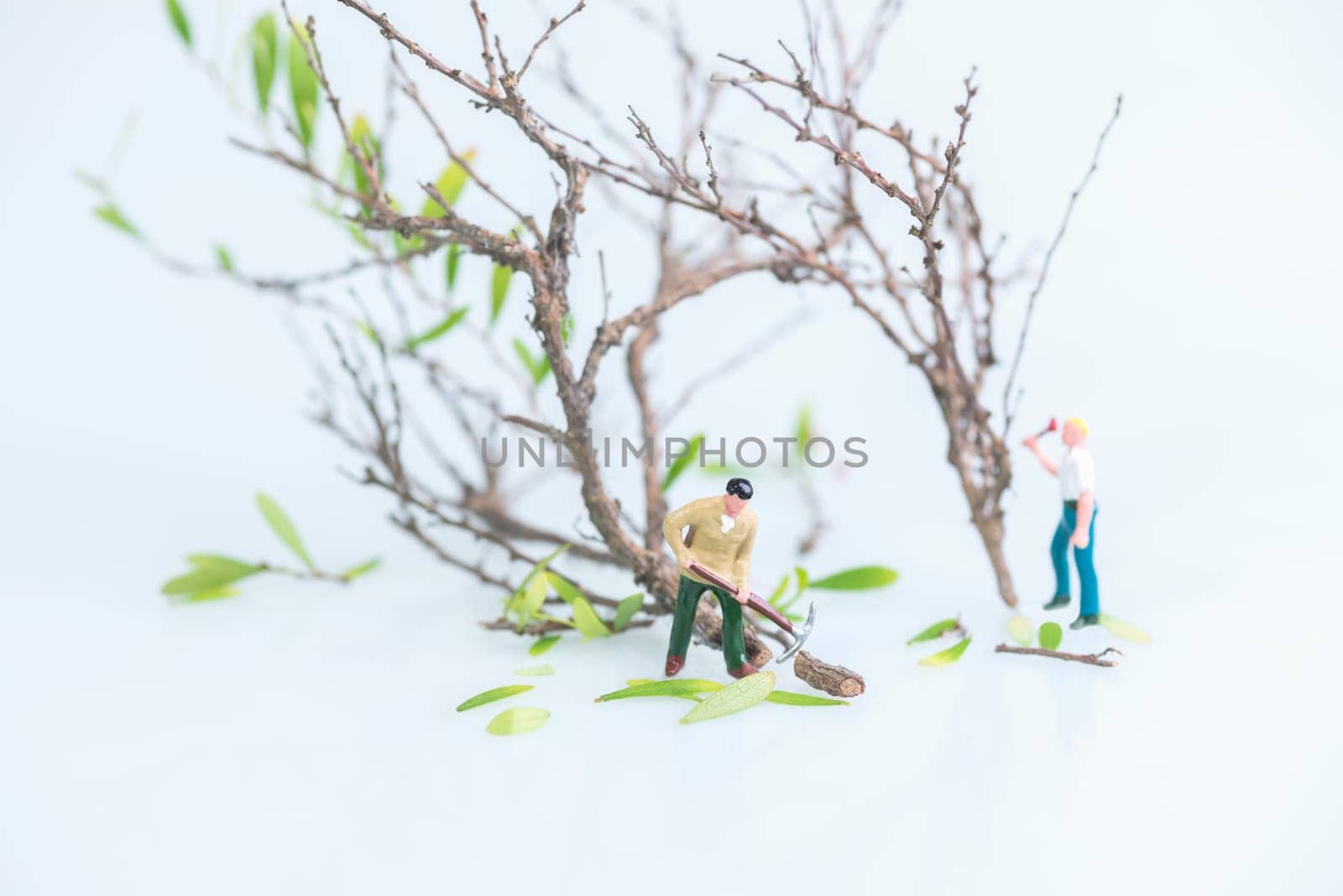 Miniature workmen cutting trees close up