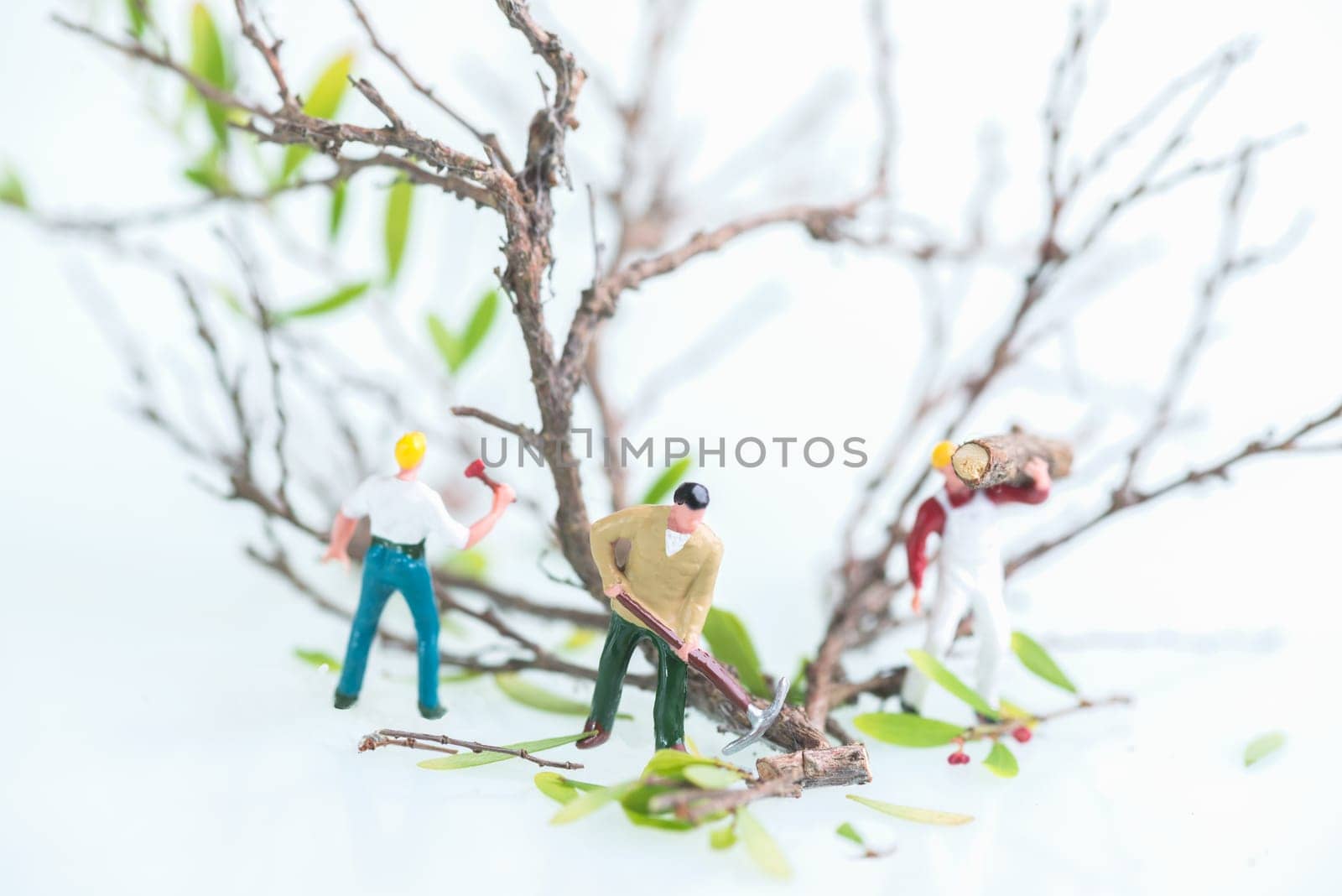Miniature men working together in felling and cutting trees