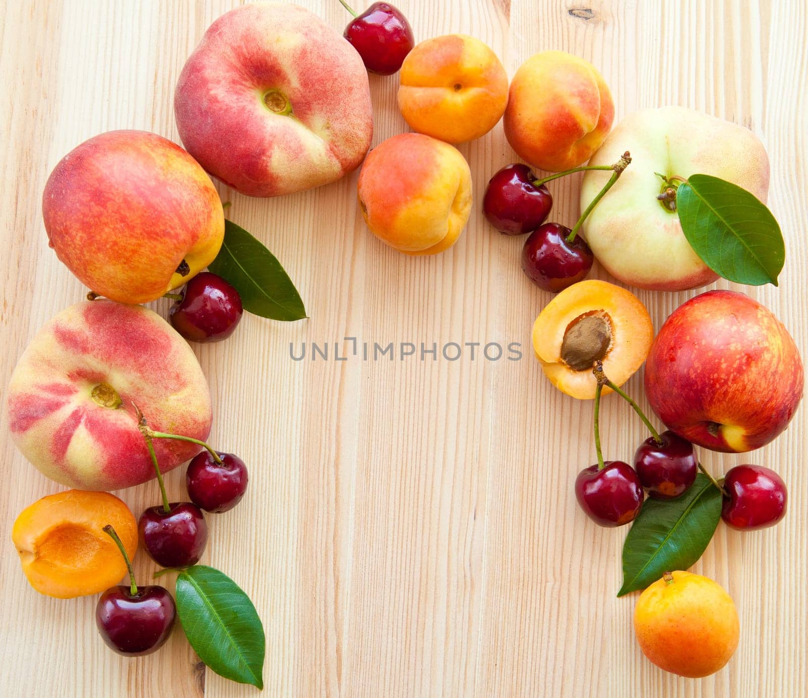 Wooden background with fresh stone fruit,peaches,cherries and apricots