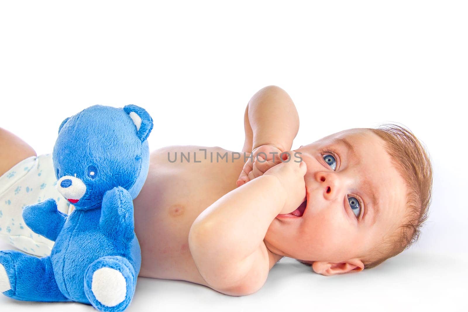 Cute blue eyed baby next to a toy