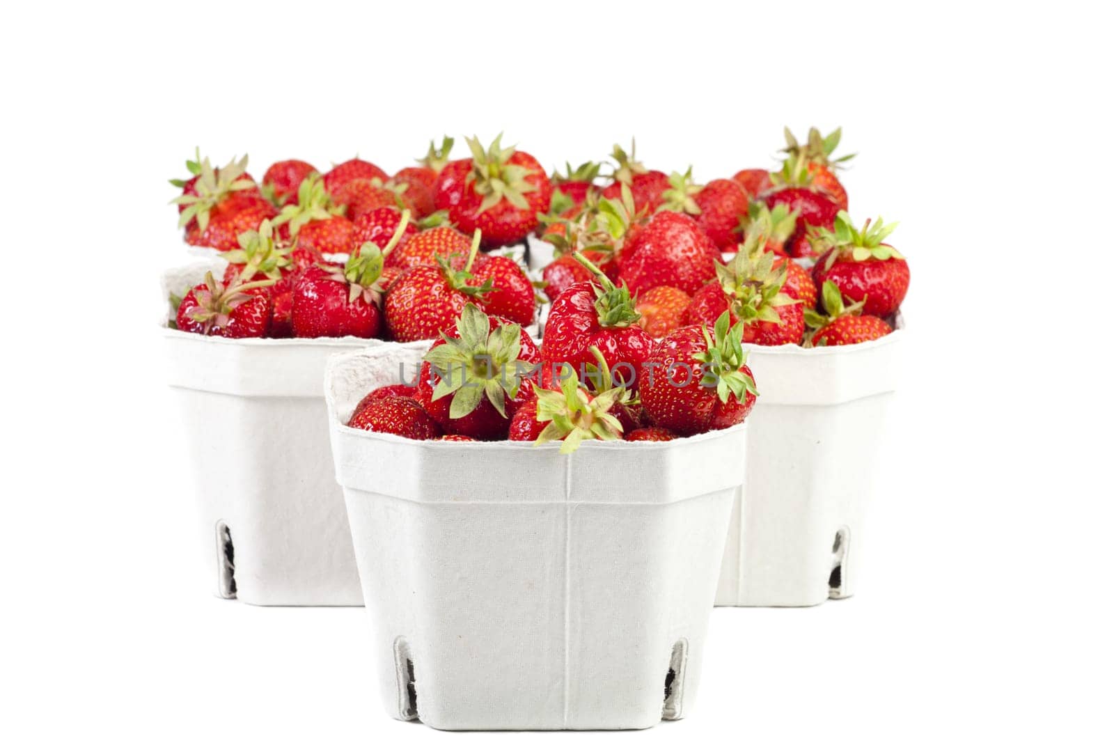 Fresh strawberries from the market in light cardboard boxes on a white background