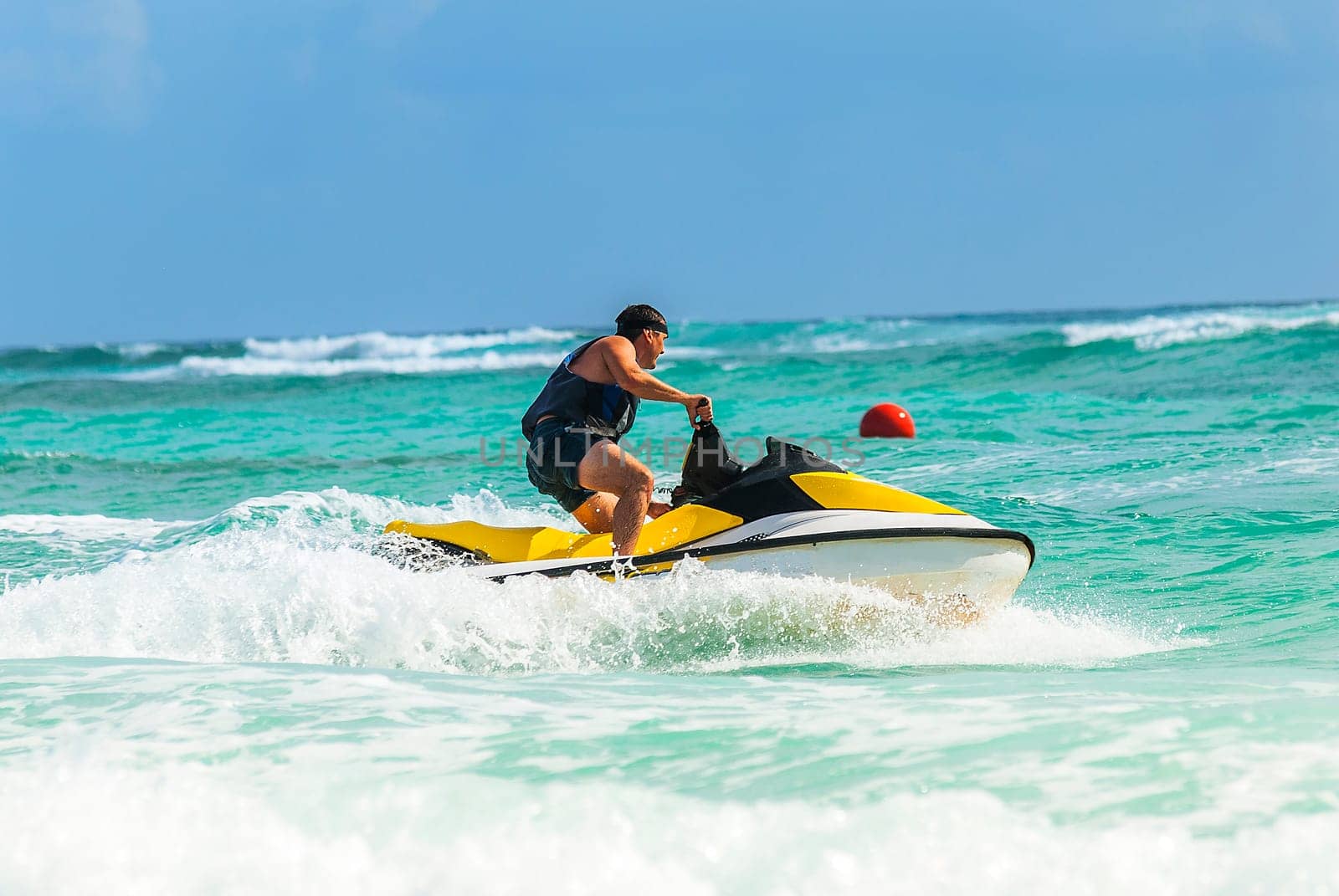 Man on Wave Runner turns fast on the water