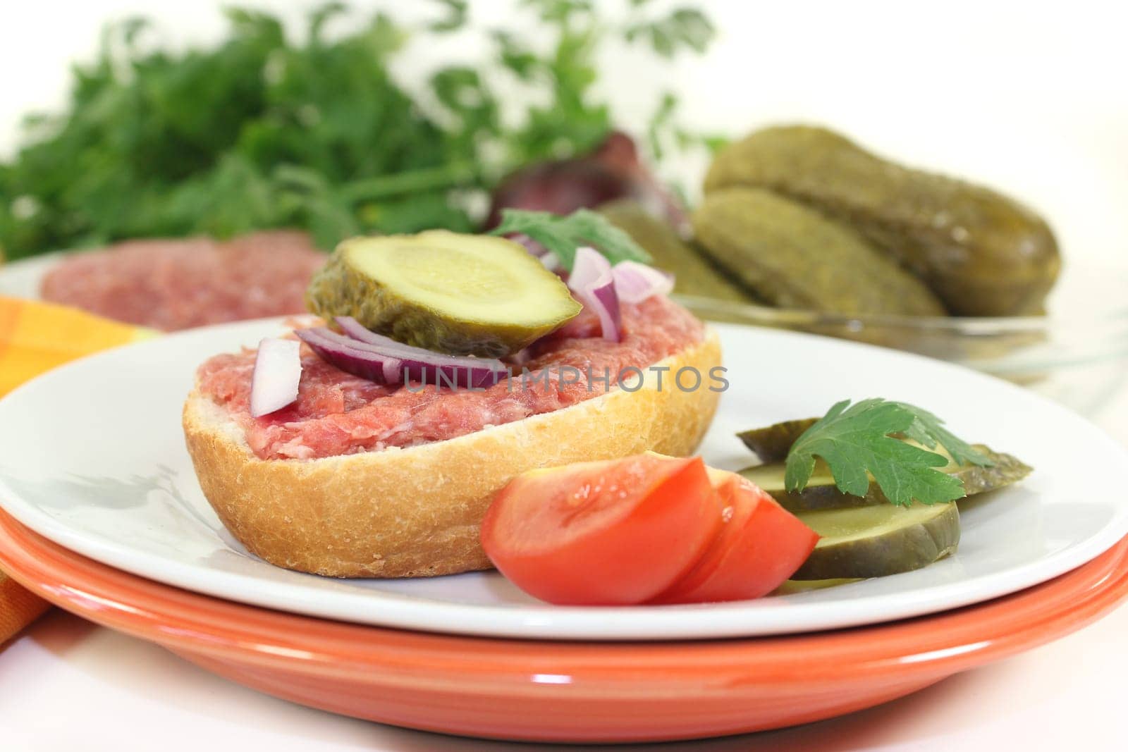 a Mettbrötchen with onion and cucumber