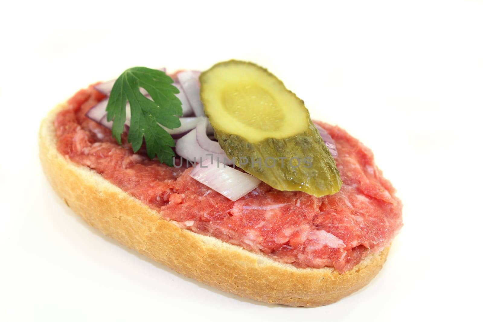 a Mettbrötchen with onion and cucumber