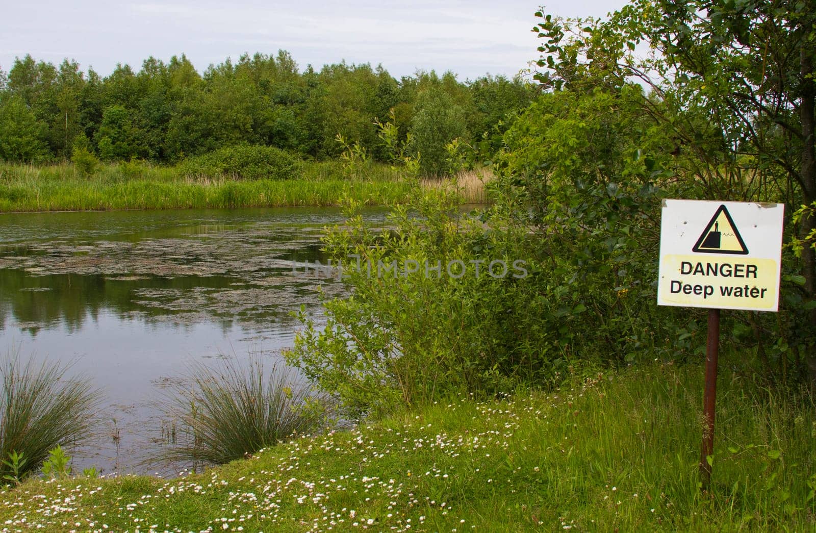 danger sign next to a lake