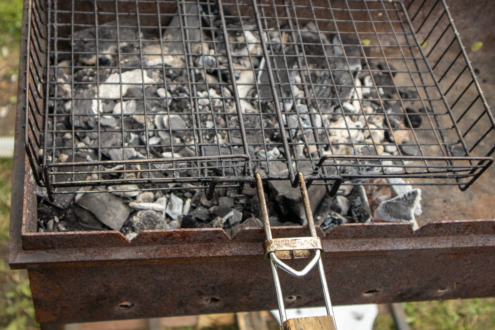 Close-up of a barbecue grill with burnt coals without fire, after cooking.