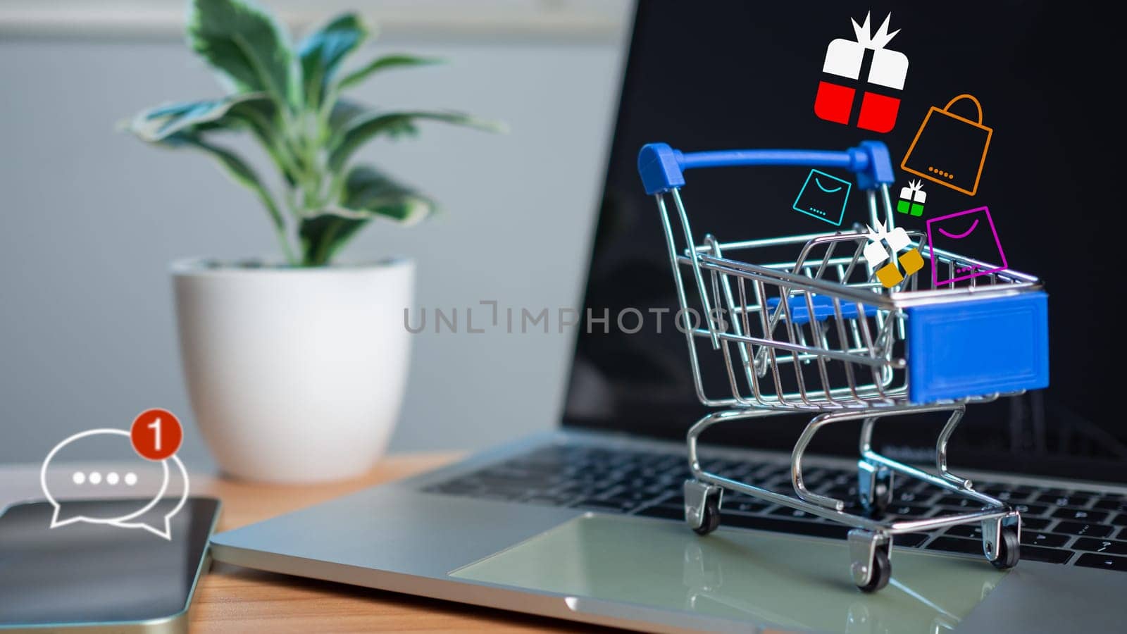 Shopping cart and gift box icons placed on laptop computer represent  online shopping concept, website, e-commerce, market platform, technology, , shipping, logistics and online payment concept. by Unimages2527